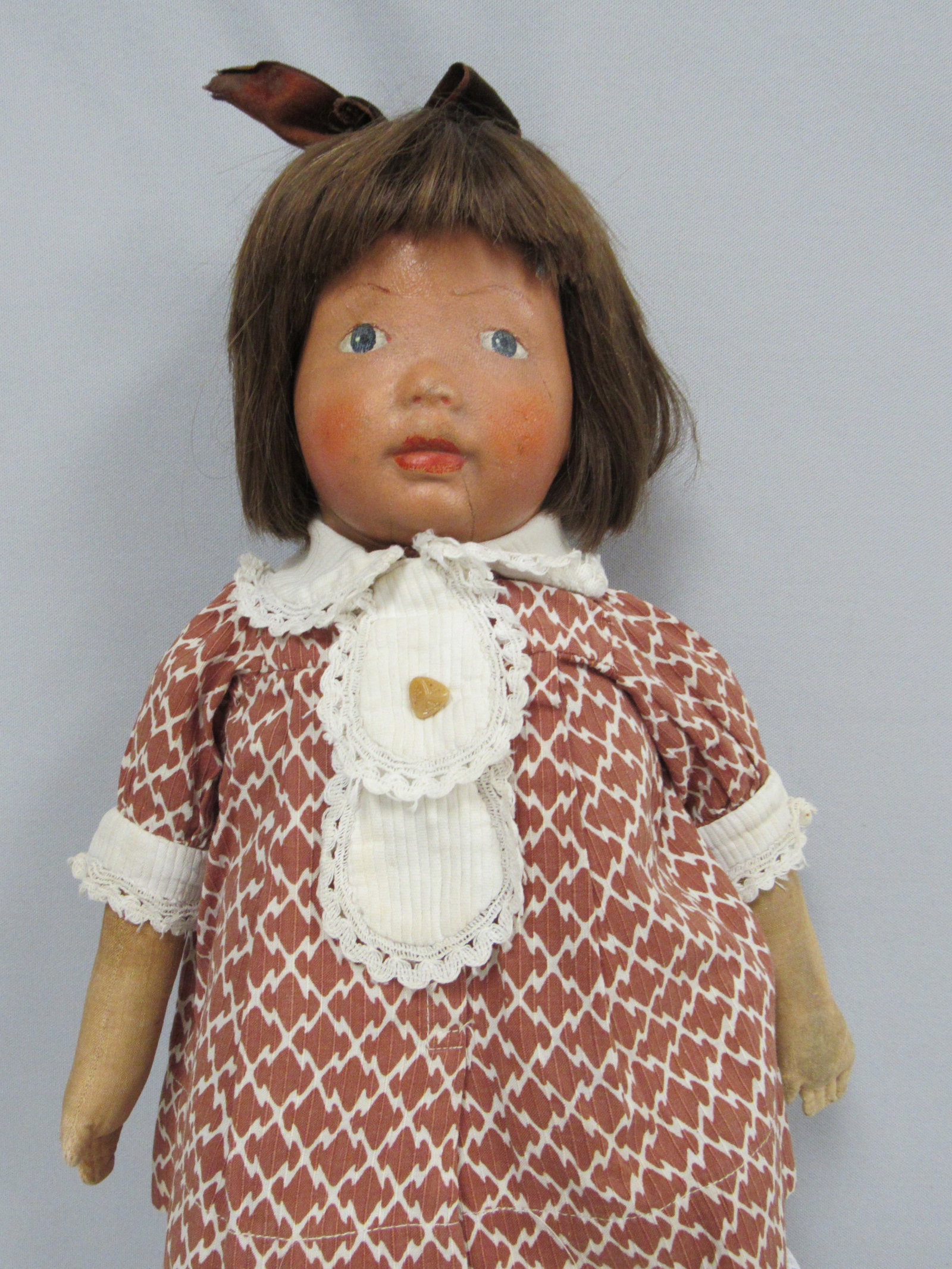 18 IN. KAMKINS GIRL:: ALL CLOTH KAMKINS WITH SWIVEL HEAD, PAINTED & MOLDED FEATURES, BLUE EYES, ROSY CHEEKS, BROWN HUMAN HAIR BOBBED WIG BROWN PRINTED COTTON DRESS (POSSIBLY ORIGINAL) ONE-PIECE COTTON UNDERWEAR, KNIT STOCK