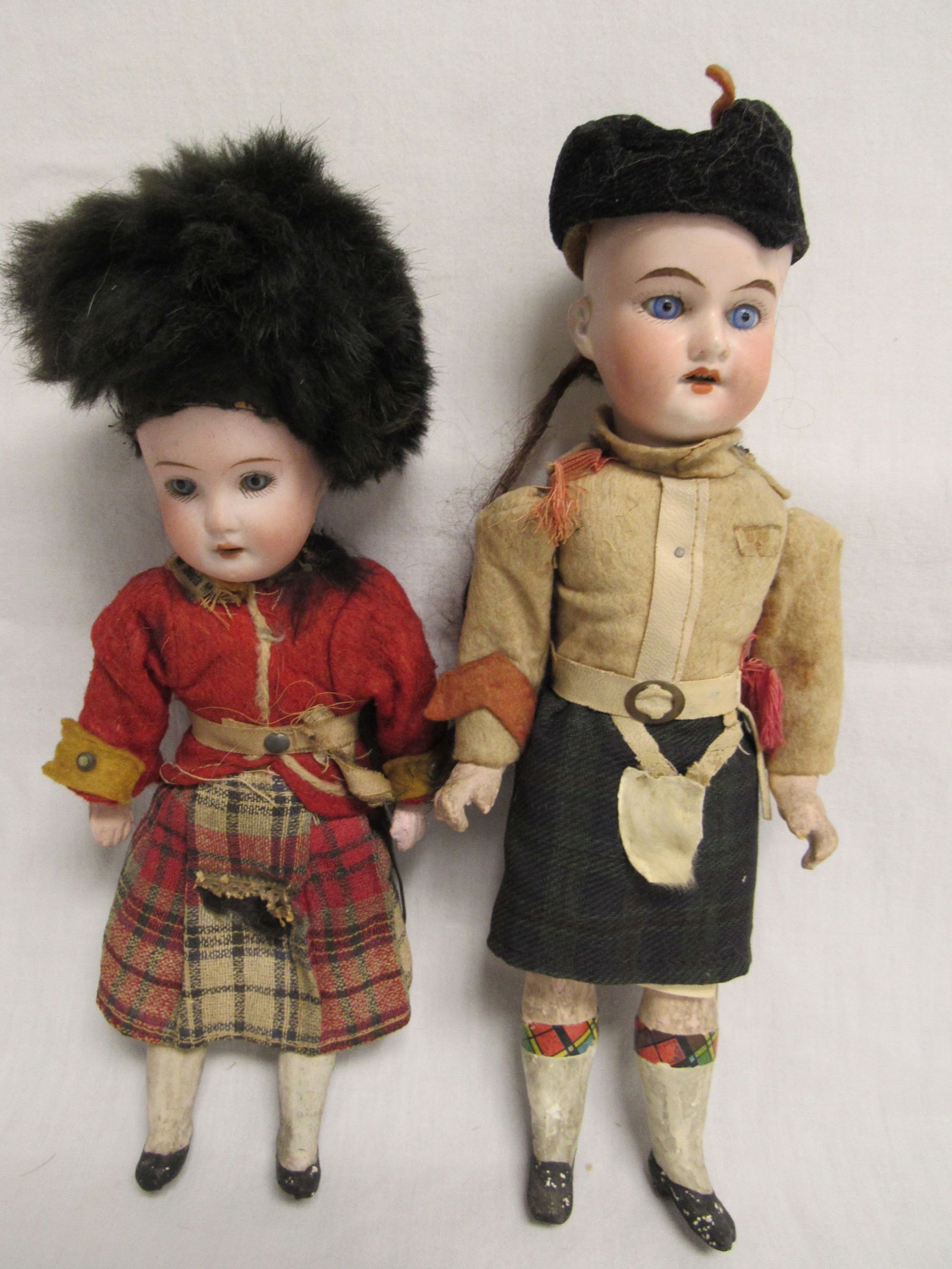 PAIR OF SOUVENIR DOLLS WITH PROEINANCE:: PURCHASED IN CANADA 1917. 9 IN. & 10 IN. BOTH IN ORIGINAL COSTUMES WITH CLEAN BISQUE HEADS & FIVE PIECE COMPO BODIES. 9 IN. HAS * ON BACK OF HEAD & PARTIAL TAG ROYAL SCOTS MA. 10 IN. IS MARKED 390 MAD