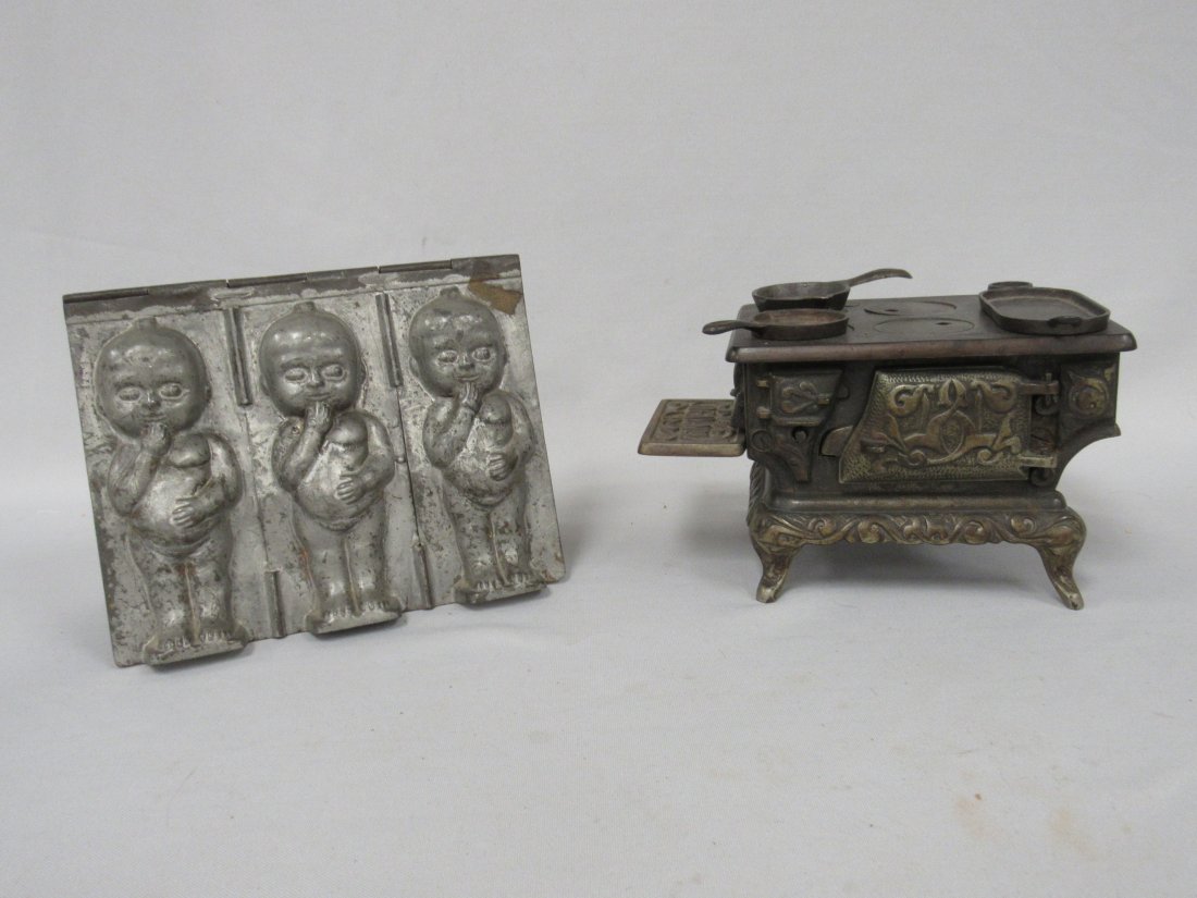 CAST IRON STOVE & CHOCOLATE MOLD:: IDEAL No.1 C.I. STOVE WITH GRIDDLE & (2) FRYPANS IS 4 IN. H, 6 1/4 IN. W AT TOP, 5 1/2 IN. W AT BASE, 5 IN. AT FEET, ATTACHED SHELF IS 3 3/4 IN. W, 1 5/8 IN. D, FREE OF DAMAGE OR REPAIRS. CHOCOLATE MO