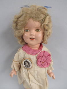 13 IN. COMPO SHIRLEY TEMPLE BY IDEAL TOY CO.:: VERY CLEAN COMPOSITION. CHIP ON RIGHT PINKY. EYES HAVE CRAZING. SHE HAS ORIGINAL WIG, PIN, ONESIE, SHOES & SOCKS. ALSO INCLUDED IS A S.T. DRESS TAG