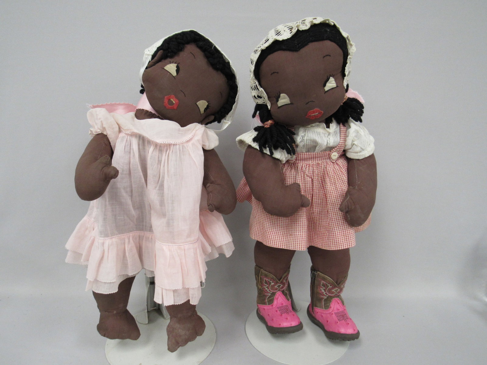 PAIR OF 21 IN. BLACK CLOTH DOLLS:: FROM THE SAME PATTERN. POSSIBLY FROM NEWSPAPER OR MAGAZINE. VERY FLOPPY. GIRL WITH BOOTS HAS HER HEAD SAFETY PINNED TO HER NECK. BOTH HAVE LIGHT STAINS ON BODIES