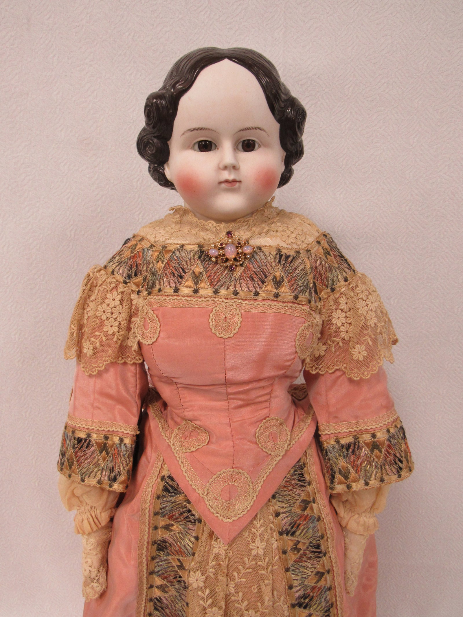 27 IN. ABG? PARIAN WITH GLASS EYES:: SHOULDER PLATE WAS REPAIRED. BISQUE HANDS, CLOTH BODY. BEAUTIFUL CLOTHING