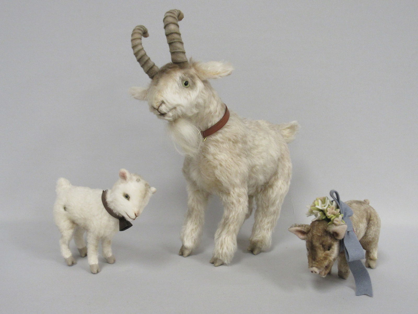 3 R. JOHN WRIGHT ANIMALS:: "SNOWFLAKE" HEIDI'S 5 IN. GOAT, LEATHER COLLAR WITH BELL, JOINTED NECK 6 IN. MOHAIR PIG, LARGE FELT RIBBON & FLOWERS, JOINTED NECK. HANG TAG SIGNED BY R. JOHN WRIGHT. "TURK" 9 IN. FELT HORNS & HOOVES,