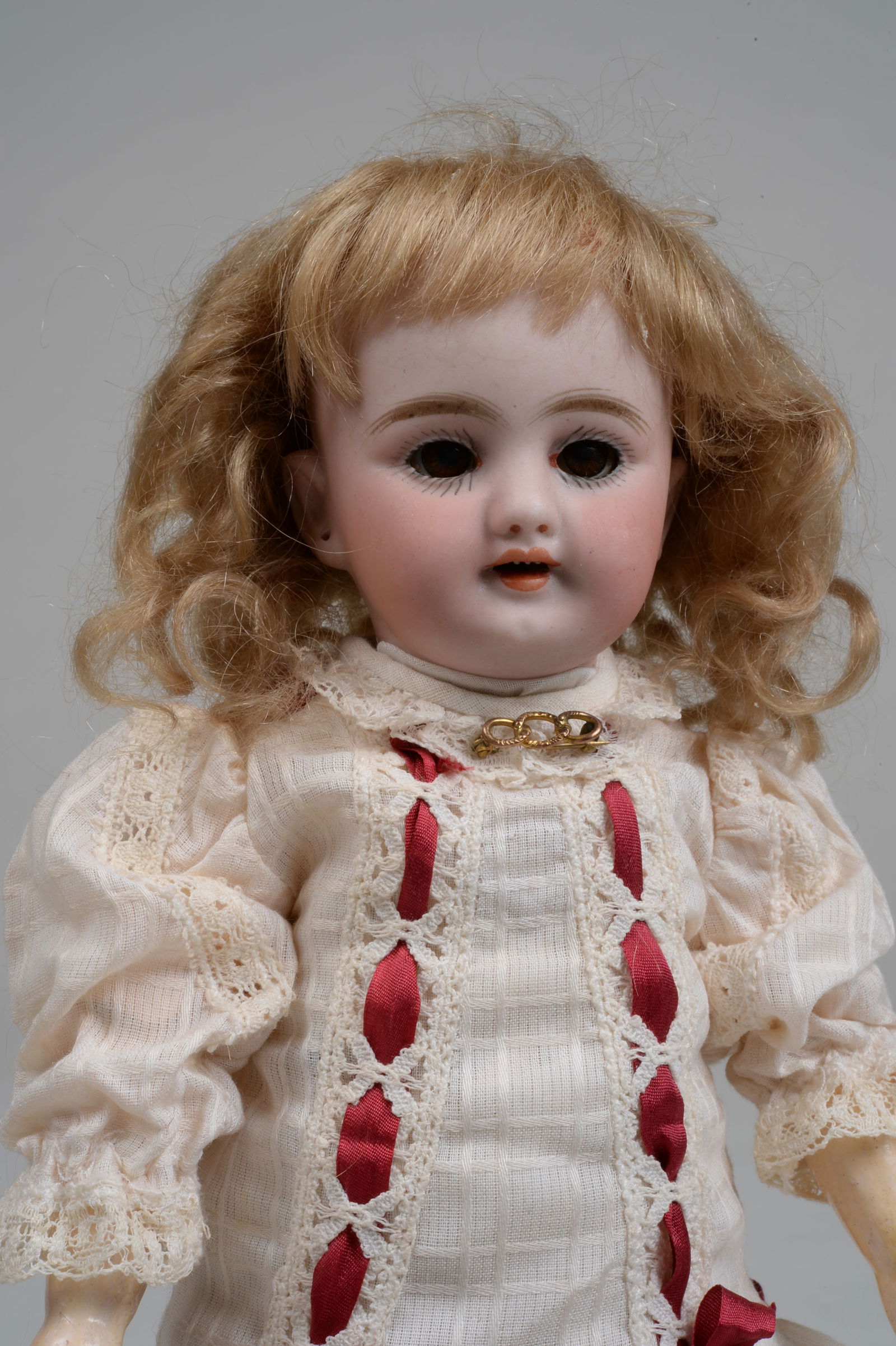 9.5 IN. TINY SIMON HALBIG 1009:: GERMANY, CIRCA 1895, PERFECT BISQUE SOCKET HEAD INCISED S 2 H 1009 DEP ST, WITH MOLDED & PAINTED FEATURES, BROWN GLASS SLEEPING EYES, BLUSHED CHEEKS, OPEN MOUTH WITH FOUR TEETH, ON HER ORIGINAL EARLY