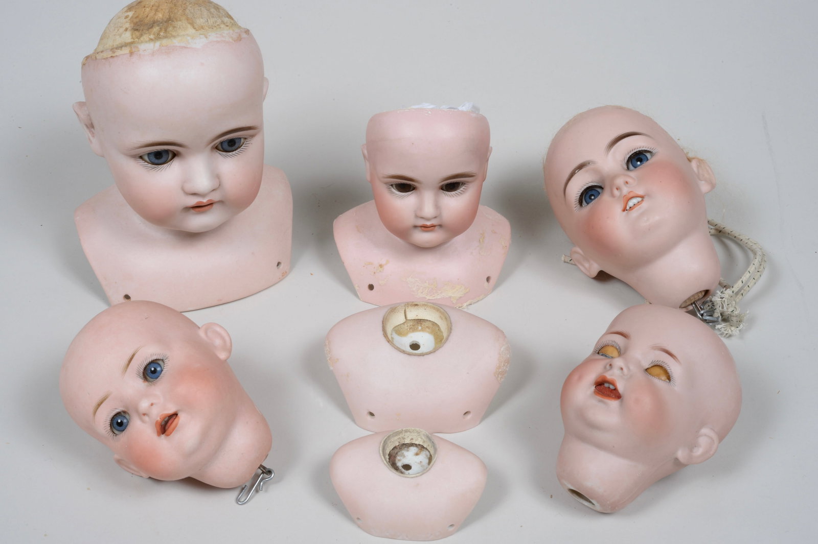 LOT OF 7 GERMAN BISQUE HEADS:: LOT INCLUDES S&H, REVALO WITH MOLDED HAIR,& HANDWERCK, ONE MISSING EYES - ALL HEADS HAVE GOOD BISQUE