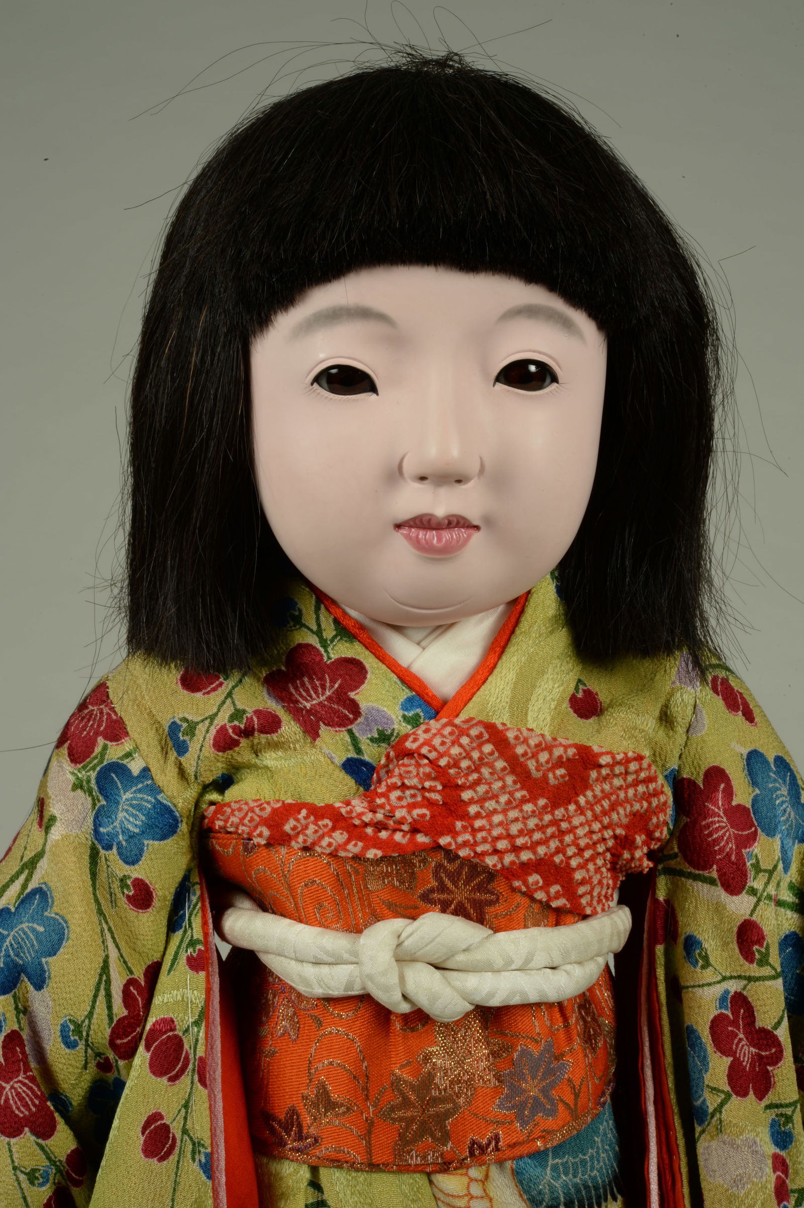 ORIG.19 IN. JAPANESE ICHIMATSU DOLL:: IN INTRICATELY PATTERNED KIMONO. JAPAN, CIRCA 1930, PAPER MACHE SWIVEL HEAD WITH GOFUM FINISH, ALMOND SHAPED BROWN GLASS EYES, LARGE MOLDED EARS, CLOSED MOUTH, ON ORIGINAL CLOTH BODY WITH MOLDED