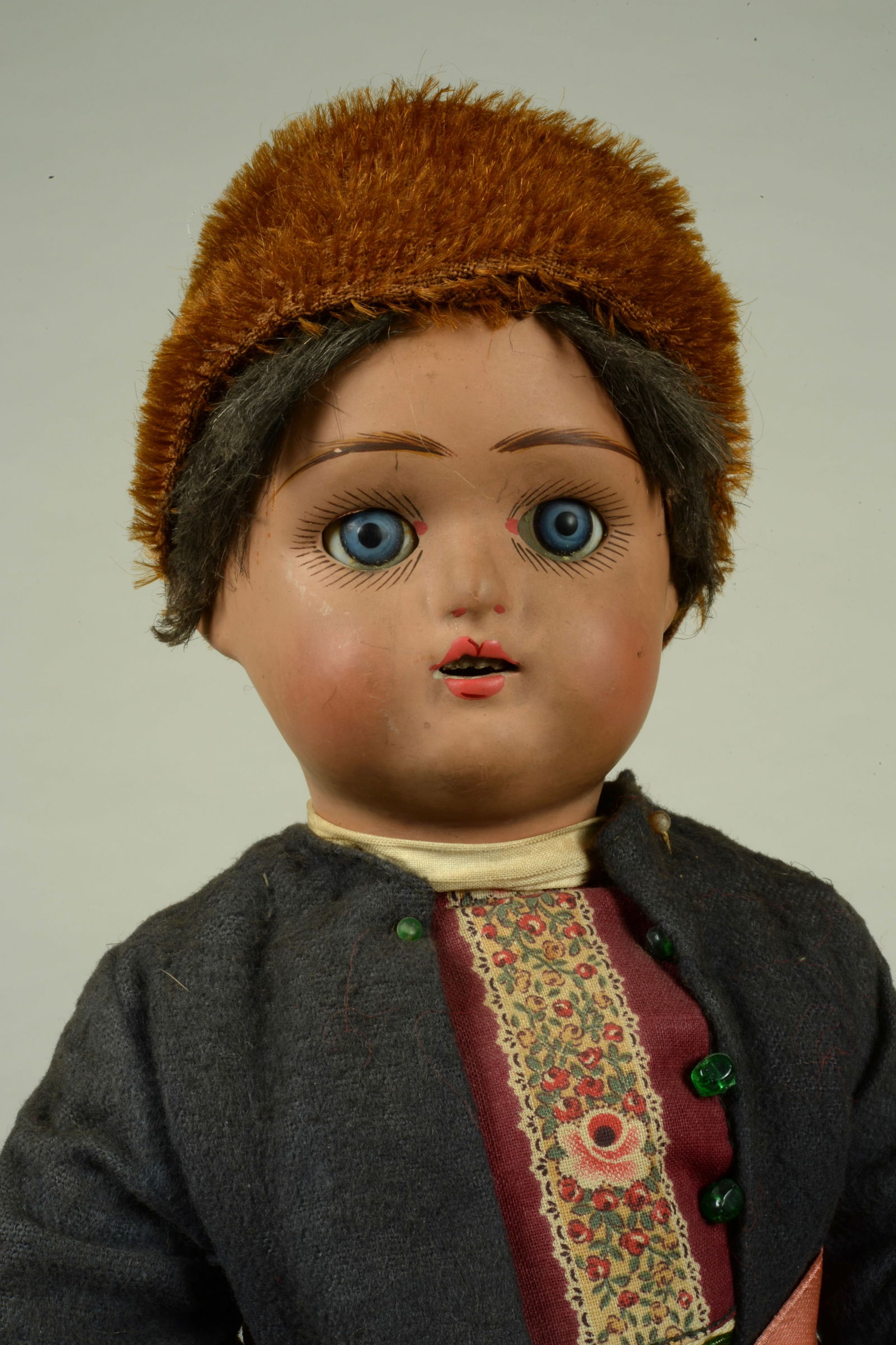 15.5 IN. ALL ORIG. RUSSIAN BOY DOLL:: IN ELABORATE AUTHENTIC COSTUME. RUSSIA, CIRCA 1915, FINE QUALITY TERRA COTTA SOCKET HEAD WITH GLASS SLEEPING EYES, WITH MOLDED & PAINTED FEATURES &AN OPEN MOUTH, ORIGINAL DARK FLAX WIG, ON HIS