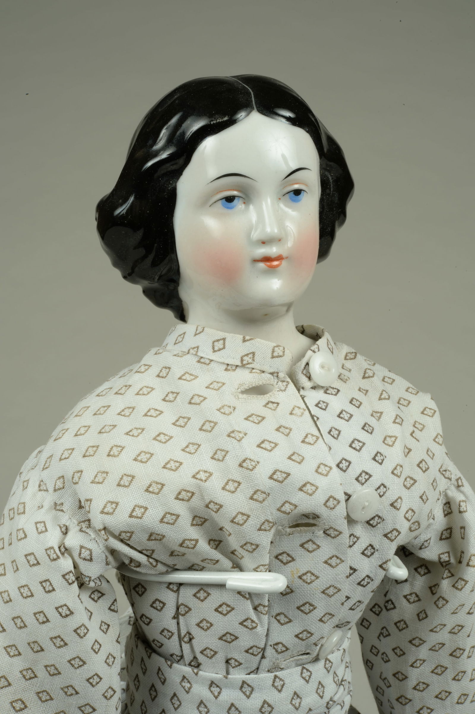 18 IN. ALL ORIGINAL JENNY LIND CHINA LADY DOLL:: GERMANY, CIRCA 1870, CHINA SHOULDERHEAD WITH MOLDED & PAINTED FEATURES, ELABORATELY COIFFED HAIR WITH COILED BUN, ON HER ORIGINAL CLOTH BODY WITH LEATHER HANDS, WONDERFUL ORIGINAL COTTON