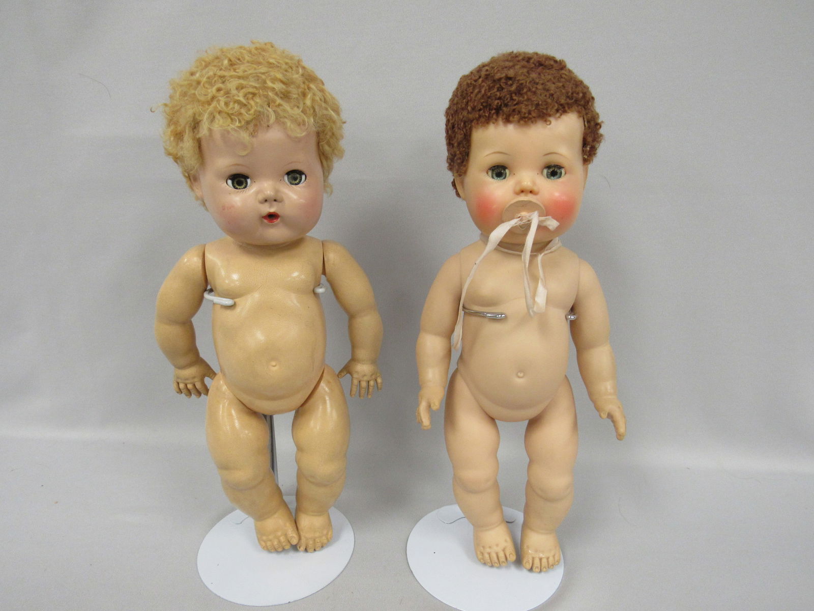 PAIR OF TINY TEARS:: RARE 12 IN. BLONDE WITH RUBBER BODY ARMS A LITTLE LOOSE, SOME SCUFFING. 12 IN. RED-BROWN HAIR VINYL BODY, HIGH COLOR, SLIGHT SCUFF RIGHT CHEEK, HAS PACIFIER - G