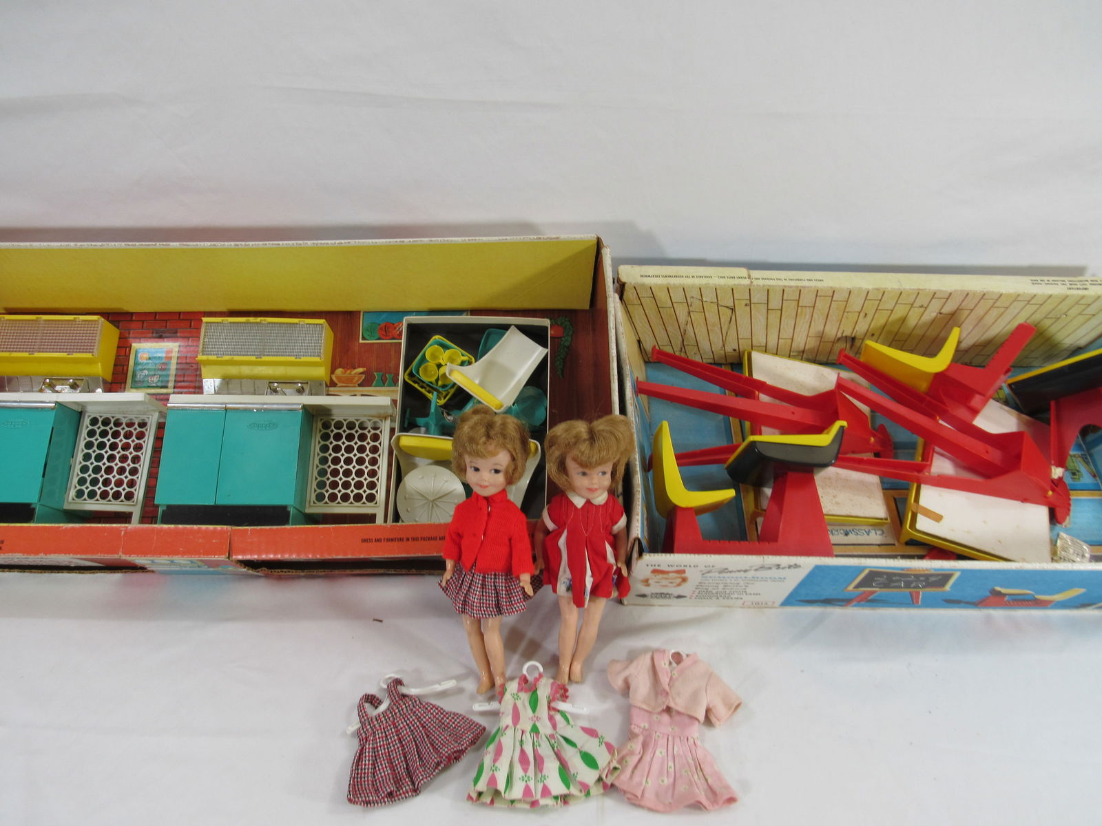 2 PENNY BRITE PLAYSETS & DOLLS:: INCLUDES 2 PENNY BRITE DOLLS WITH 3 OUTFITS, KITCHEN DINETTE WITH 2 SINKS, PLATES, CUPS, 3 CHAIRS, NO TABLE, SCHOOL ROOM, 2 EASELS, 2 DESKS (1 BROKEN) & ERASERS (NOT COMPLETE) - G