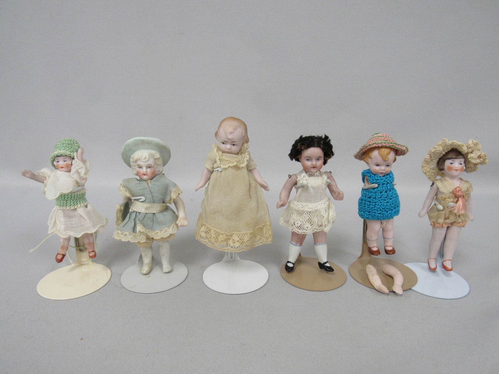 6 SMALL ALL BISQUE DOLLS:: INCLUDES 3.5 IN. FLAPPER/CROCHET ACCENTS, 3.5 IN. FLAPPER ORIGINAL, 4 IN. BOY WITH HAT IN BATHER OUTFIT, 4 IN. WITH HAIR & HAT, 3 IN. "MIBS" & 3 IN. "MIBS" (NEEDS ARMS RESTRUNG) - G