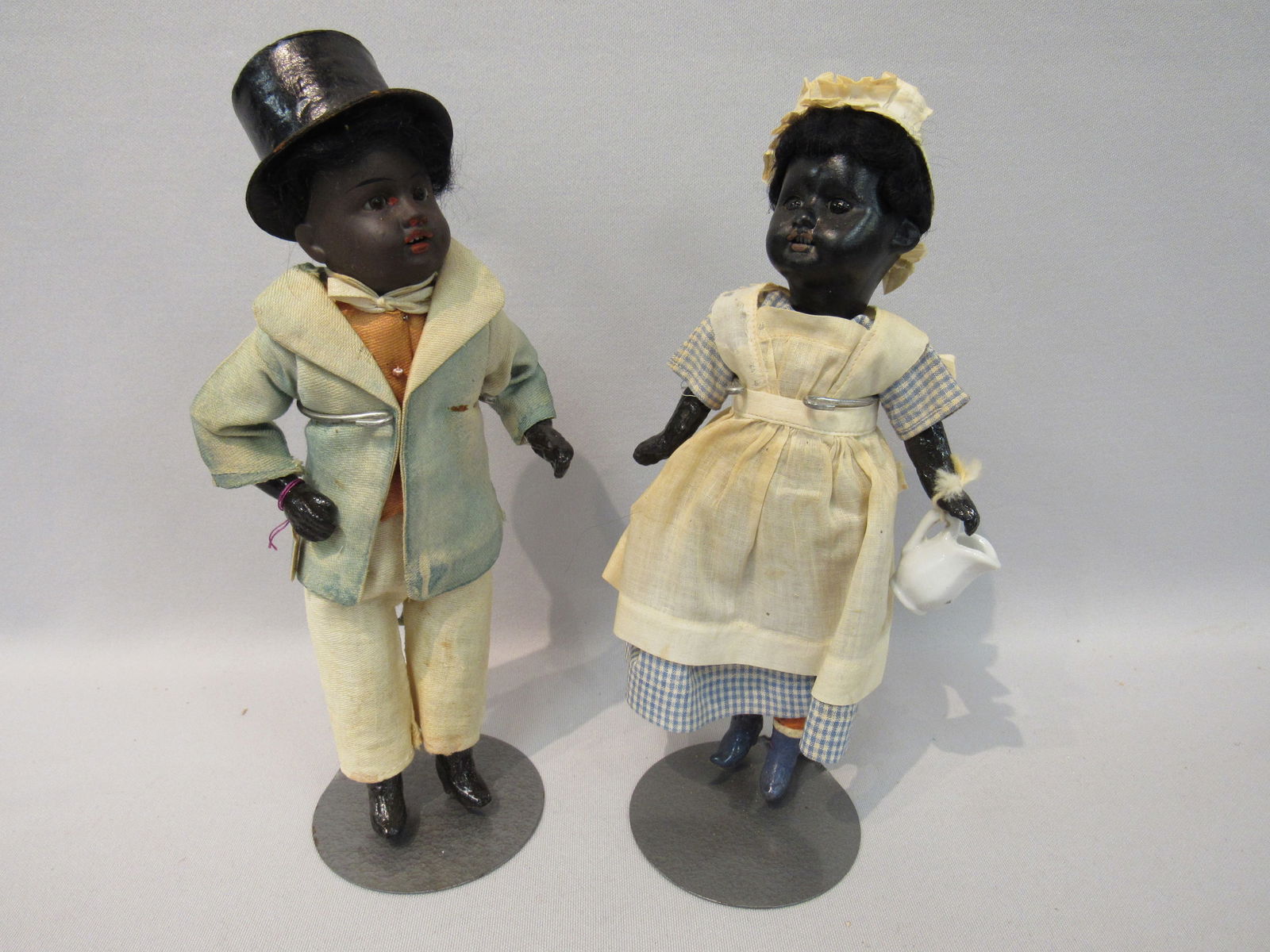PAIR OF BLACK ANTIQUE DOLLS:: INCLUDES 10 IN. MAN WITH TOP & TAILS (FADED) GEBRUDER KUHNLENZ MARKED 34-14 BISQUE HEAD, SET EYES, OPEN MOUTH WITH TEETH, DAMAGE FREE, COMPO 5 PIECE BODY. 8 IN. BLACK GIRL, DRESSED AS A MAID, POSSIBLY