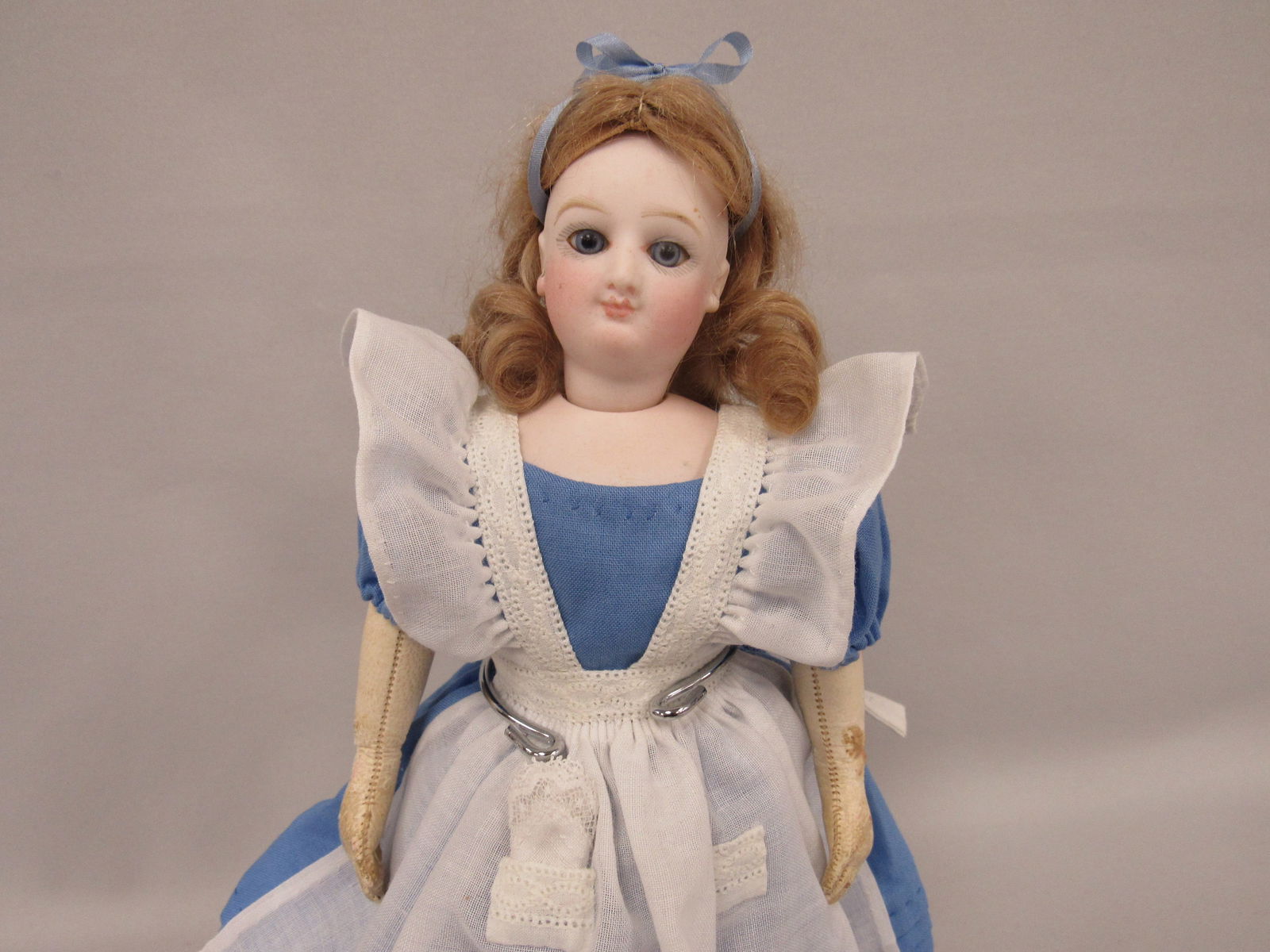 10.5 IN. SMILING BRU FASHION:: PERFECT SOCKET HEAD & SHOULDER PLATE, SET GLASS EYES, CLEAN LEATHER BODY, LEFT ARM REPAIR, DRESSED AS ALICE IN WONDERLAND WITH DRINK ME BOTTLE & WHITE RABBIT - G