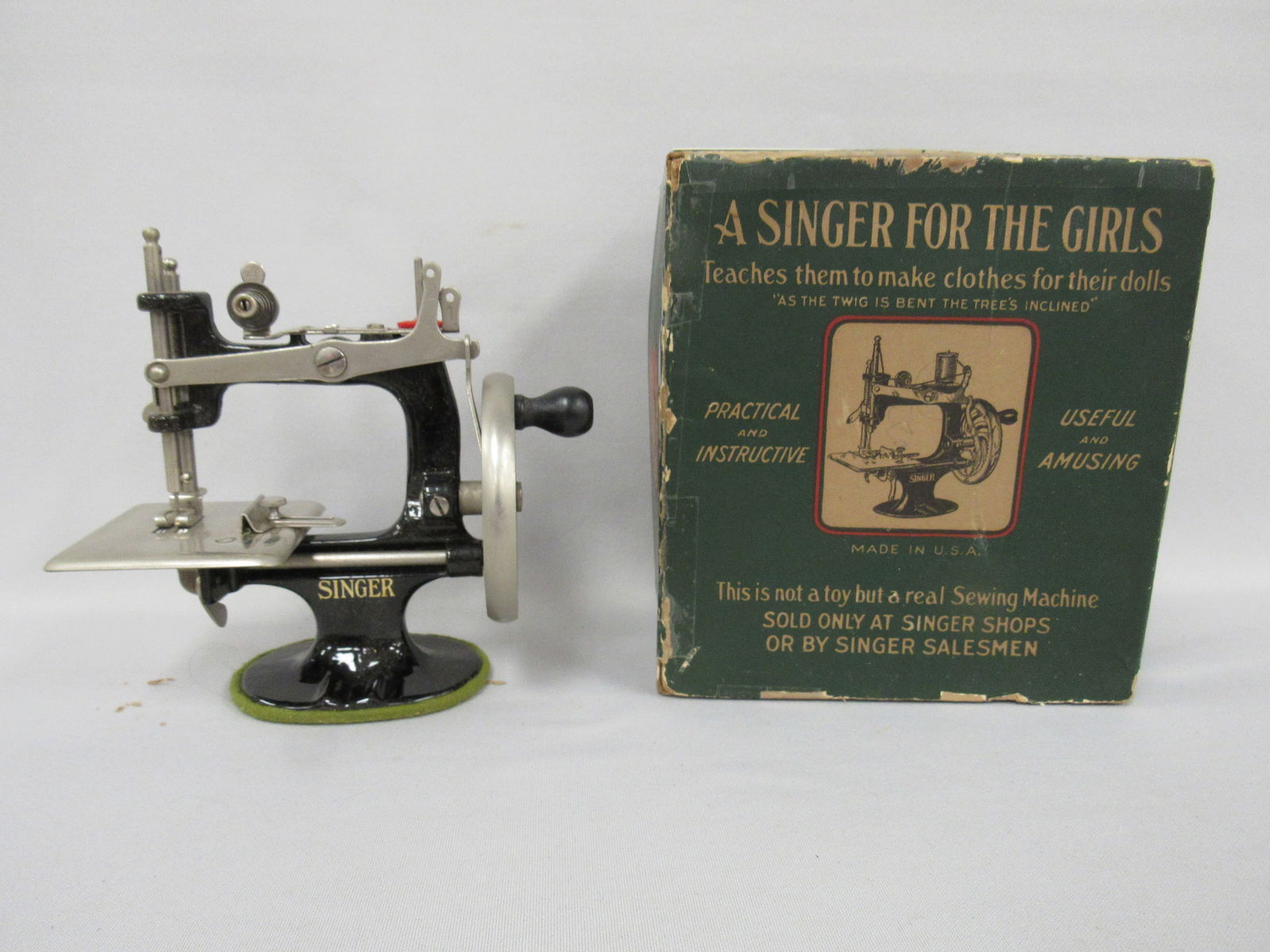 BOXED 1926 GIRLS SINGER SEWING MACHINE:: CAST IRON WITH INSTRUCTION BOOKLET, NEEDLES & THREAD, NOT INCLUDED IS A CLAMP TO ATTACH TO A TABLE. BOX TOP IS REINFORCED & TAPED, BOTTOM IS TAPED WITH A PIECE MISSING. MACHINE IS VG. - VG/G