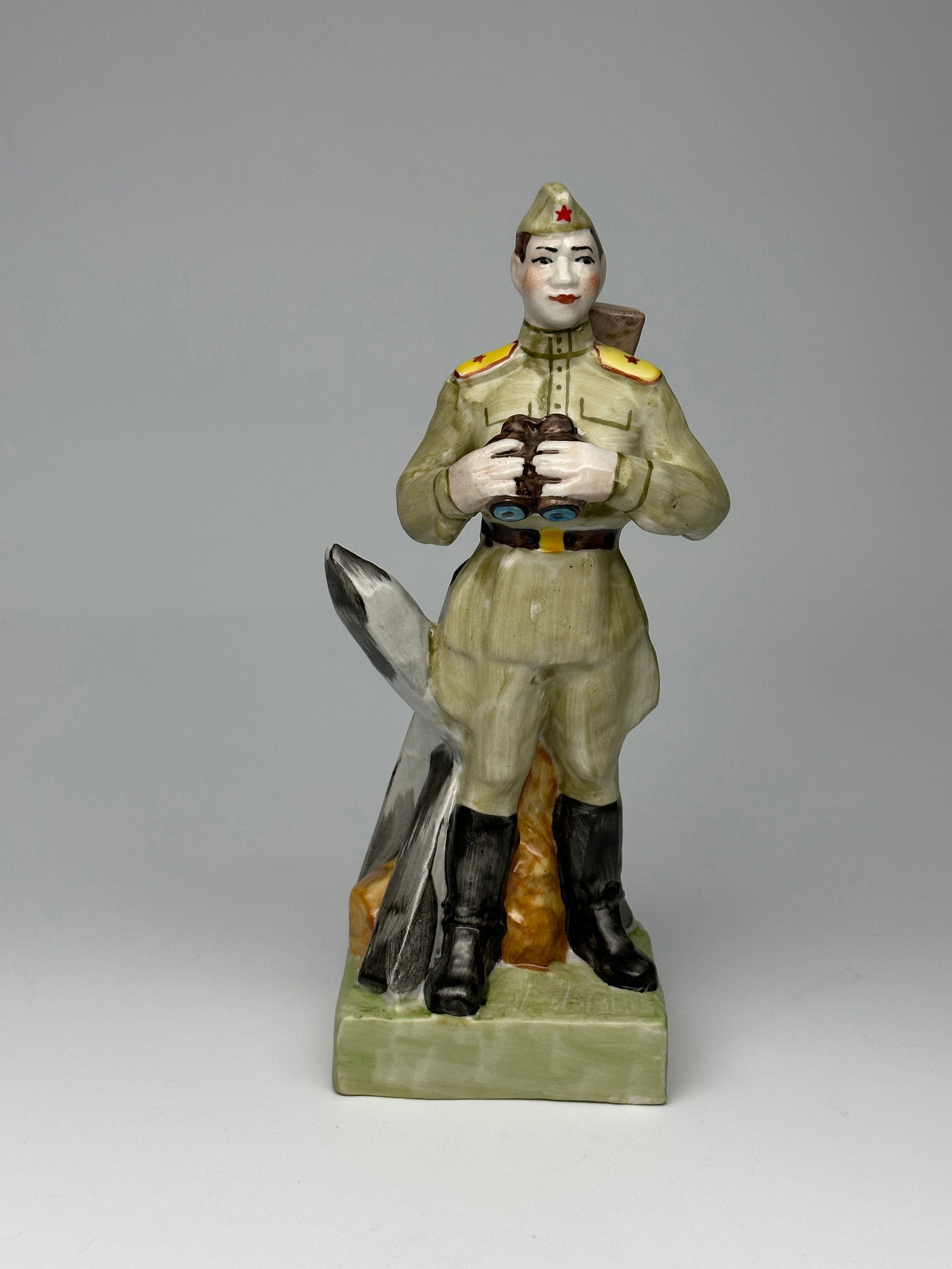 Rare Vintage Soviet Porcelain WWII Figurine "The Red Army Soldier with Binoculars" Baranovka Factory: The figure depicts a Red Army soldier observing the battlefield with binoculars in hand. Slung over his back is a PPSh-41 submachine gun. Behind him is an anti-tank "Hedgehog" obstacle. Makers mark on