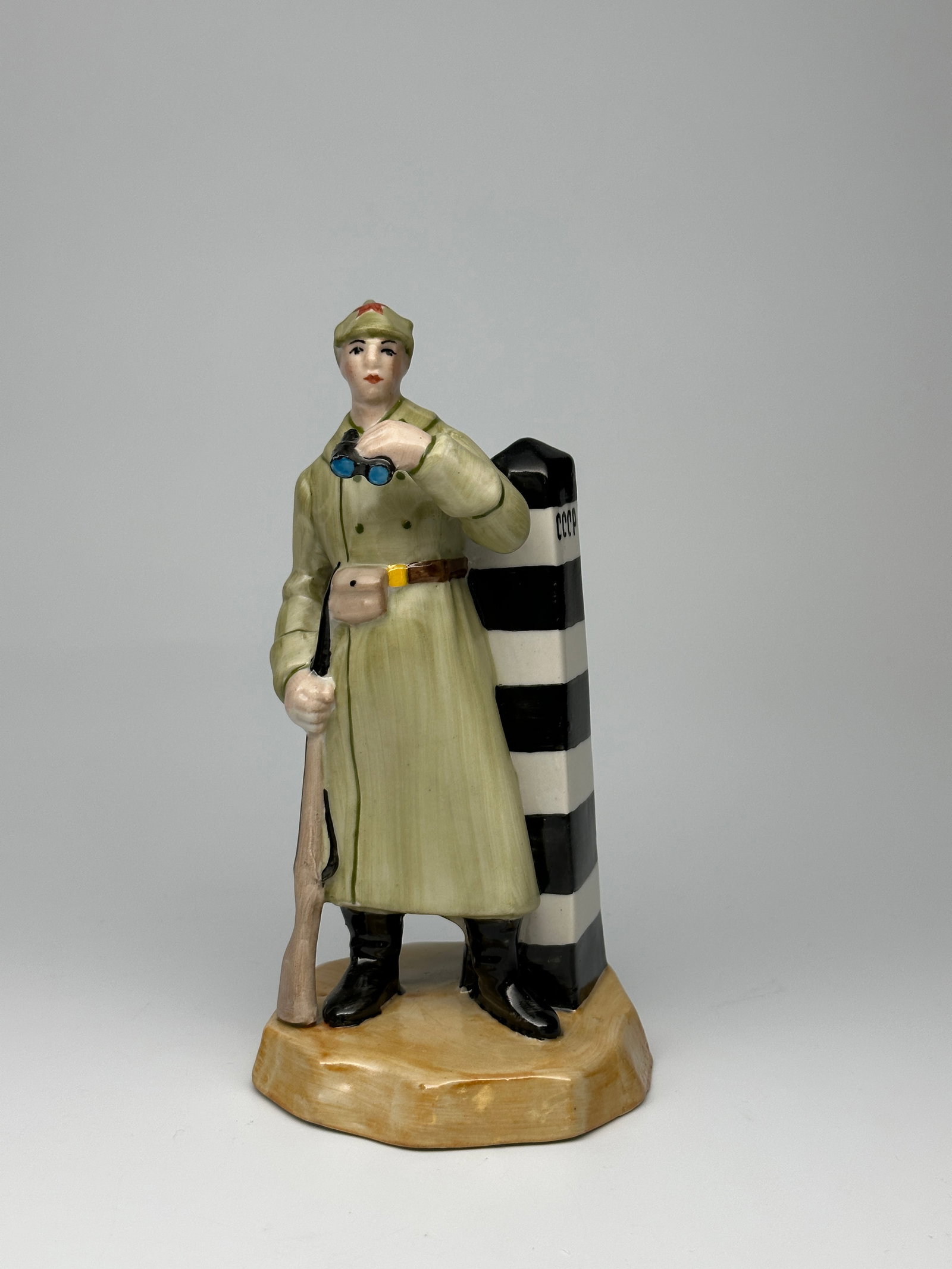 Rare Vintage Soviet Porcelain WWII Figurine "The Border Guard" Baranovka Factory: This sculpture depicts a borderguard armed with a rifle observing the landscape with binnoculars. Next to him is a striped border post on which "CCCP" is written. Makers mark on underside. Signed "Pri