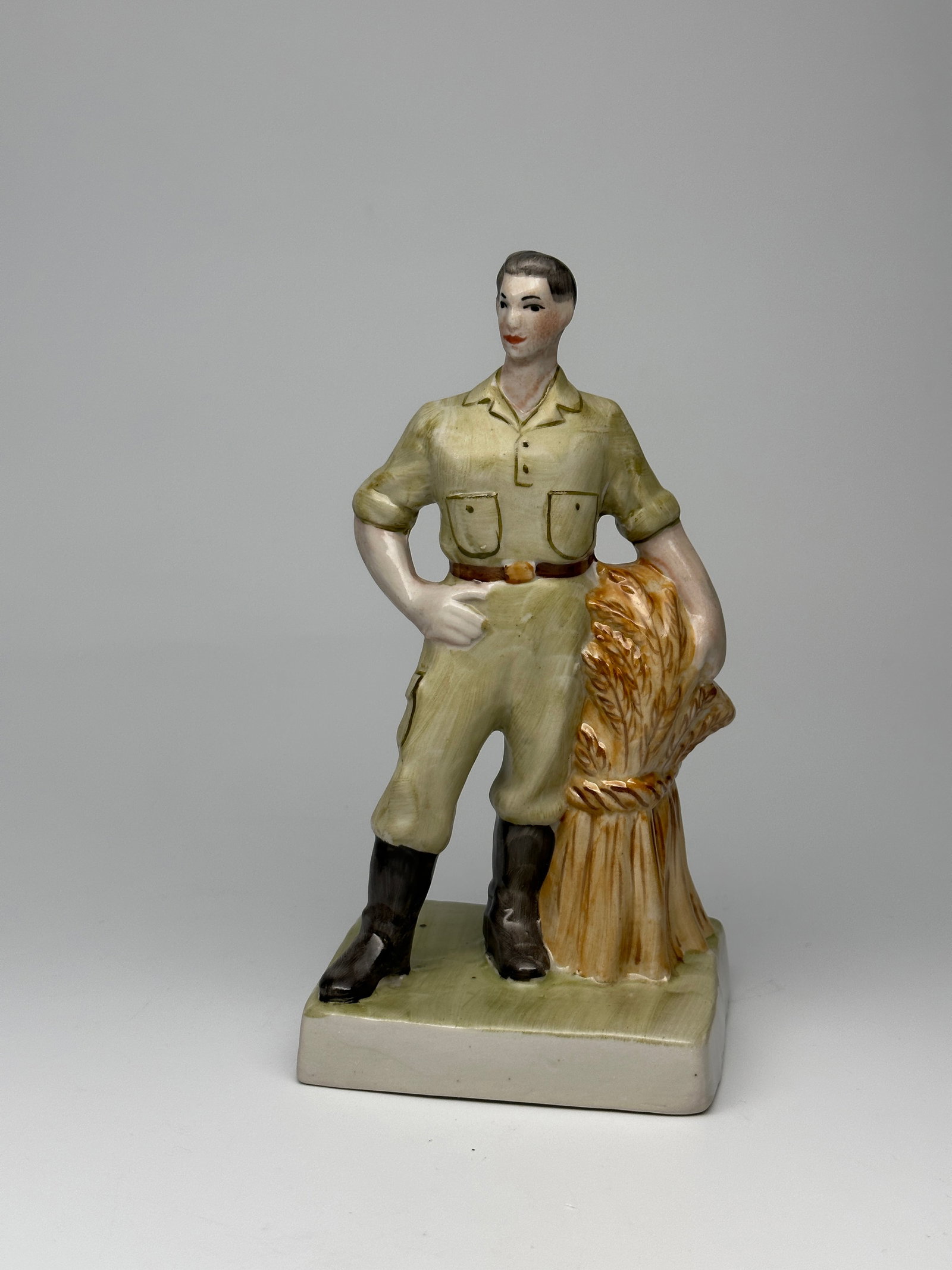 Rare Vintage Soviet Porcelain WWII Figurine "Worker with wheat" Baranovka Porcelain Factory: A Soviet Porcelain Figurine of a worker standing next to a bountiful sheaf of wheat. Figures such as these celebrated the working class in the USSR. Makers mark on underside. Signed "Prisyazhnyuk&rdqu