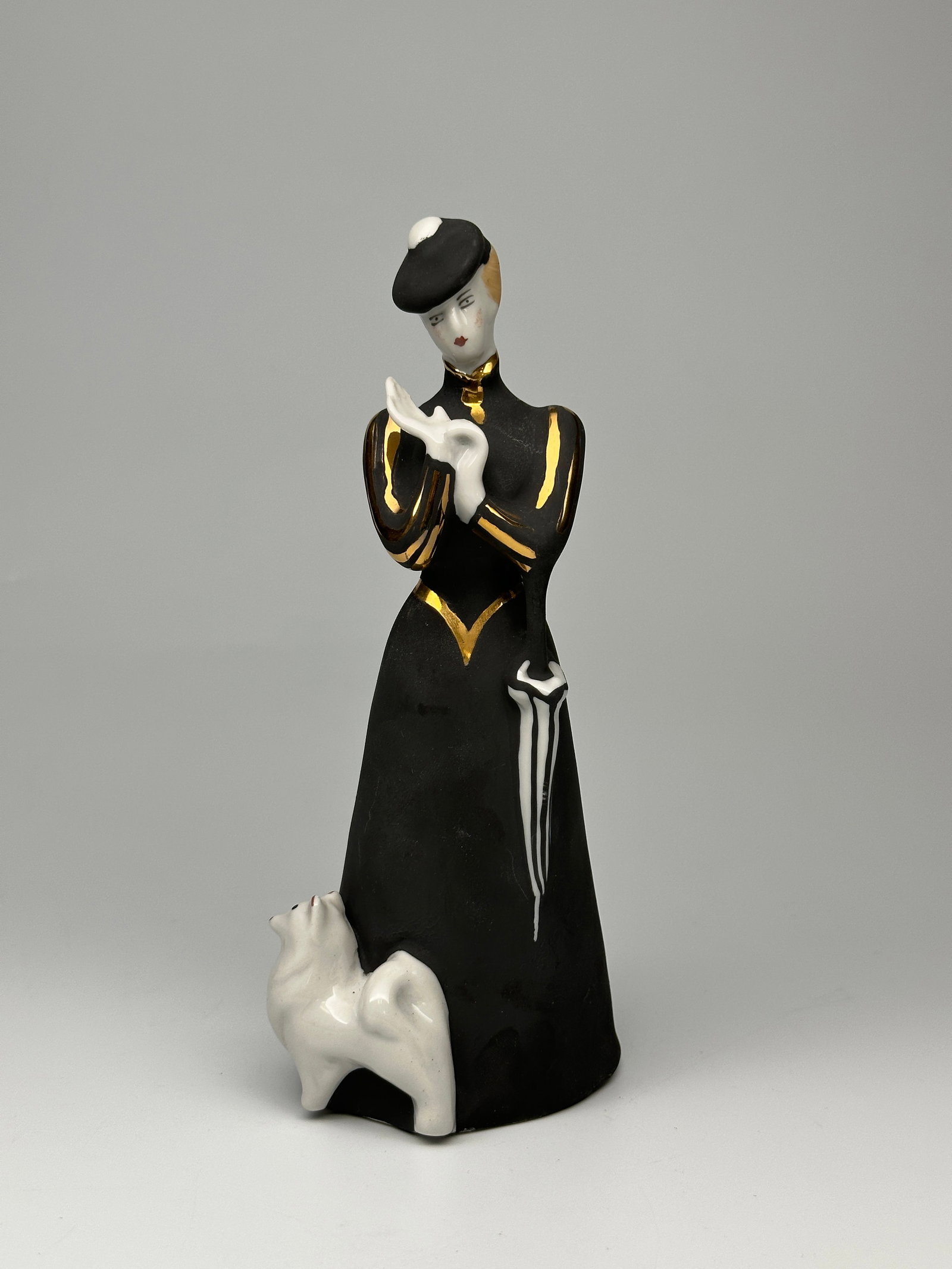 Soviet Porcelain Figurine "Victorian Lady with a Dog" Dulevo Porcelain Factory: Dulevo Porcelain Figurine of Victorian Lady with dog dressed in a black overcoat and hat with an umbrella taking her walk out for a walk. Dulevo Porcelain Factory The Dulevo Porcelain Factory was foun