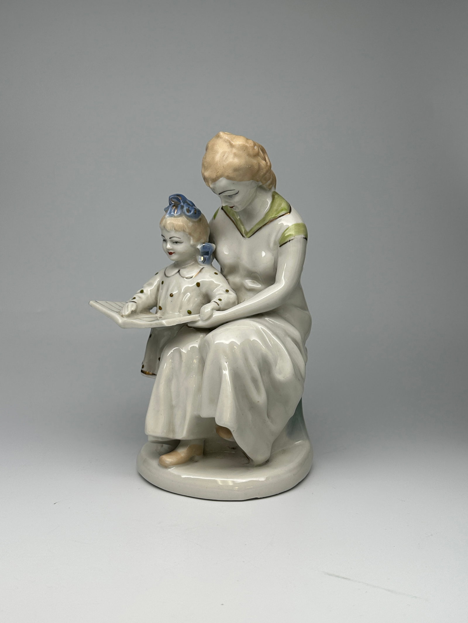 Soviet Porcelain Figurine "First Letter" (Polonsky Porcelain Factory): This vintage Soviet porcelain figurine depicts an endearing and heartwarming moment between a mother and her child while she is teaching her daughter to read. This figurine was an iconic sculpture tha