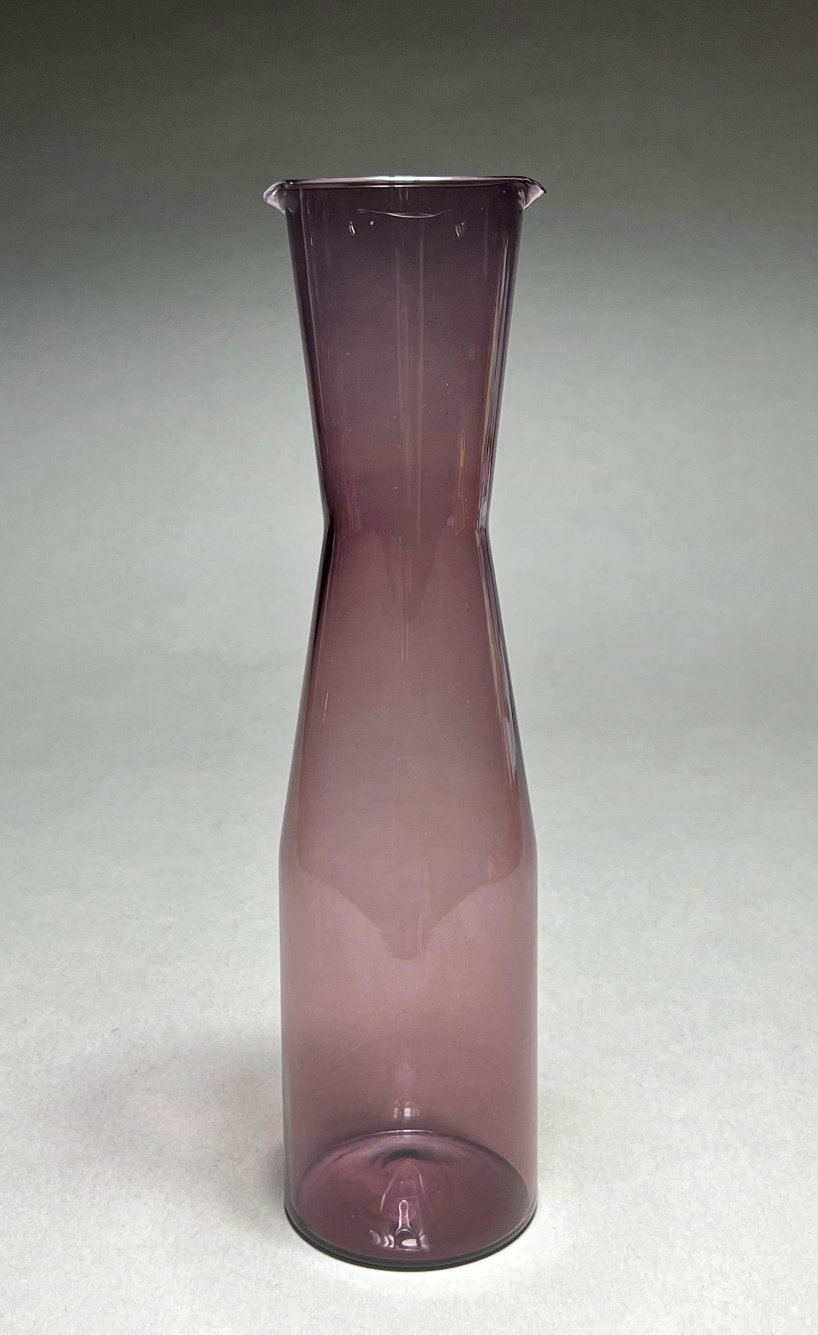 Timo Sarpaneva i-glass Amethyst Glass Decanter for Iittala - c.1960s: Timo Sarpaneva i-glass Amethyst Glass Decanter for Iittala - c.1960s Modernist decanter featuring a slender, gracefully cinched silhouette in luminous amethyst glass. The piece displays a subtle hourg