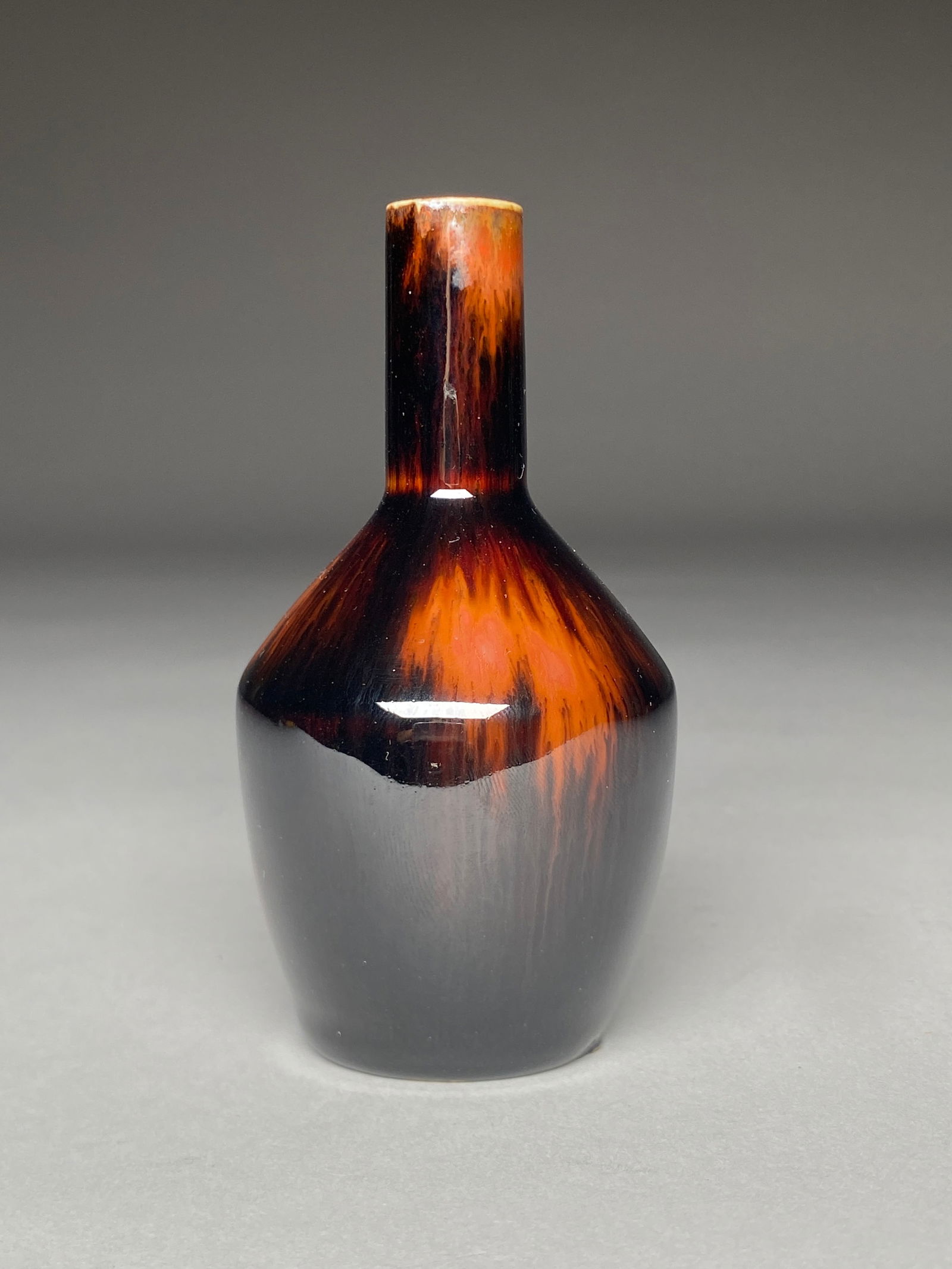 Carl-Harry Stalhane Stoneware Vase - Mid 20th Century: Carl-Harry Stalhane Stoneware Vase - Mid 20th Century This compact vase with a narrow cylindrical neck rising from a rounded shoulder tapering into a small base. The glaze is a deep brown-black with f
