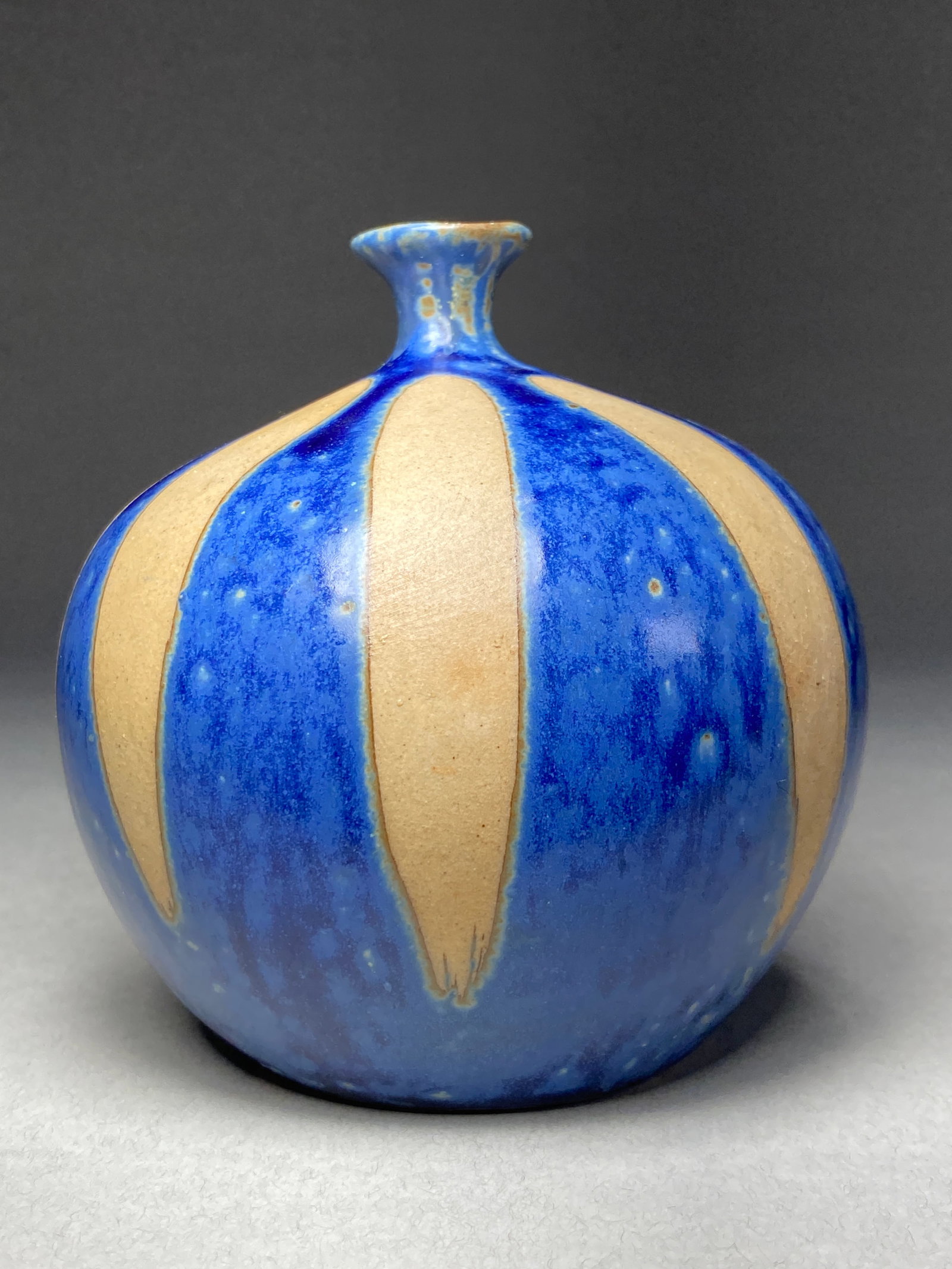 Mid-Century Studio Ceramic Vase with Cobalt & Buff Contrast: Mid-Century Studio Ceramic Vase with Cobalt & Buff Contrast A studio ceramic vase featuring dramatic interplay between rich cobalt blue glaze and unglazed buff stoneware. The cobalt sections showcase