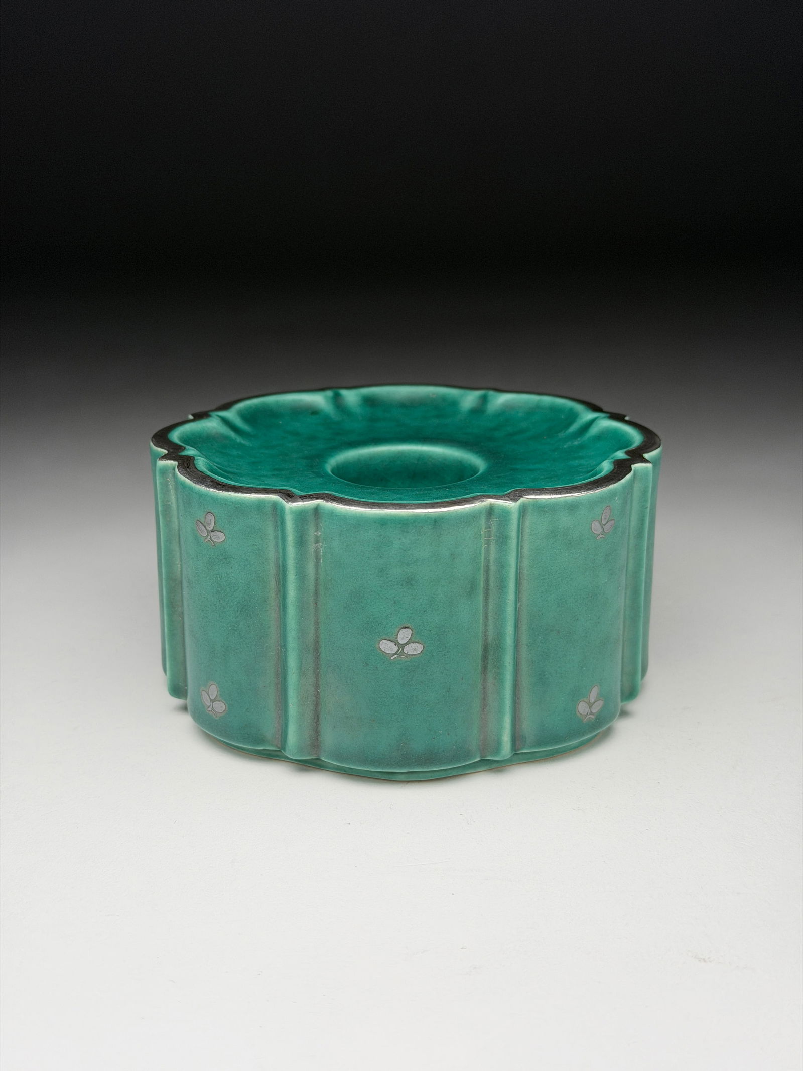 Wilhelm Kage Argenta Stoneware Candle Holder with Silver Clover Motifs - 1936: Wilhelm Kage Argenta Stoneware Candle Holder with Silver Clover Motifs - 1936 A candle holder with vertical fluted sides and a scalloped rim, finished in a soft turquoise-green glaze with subtle tonal
