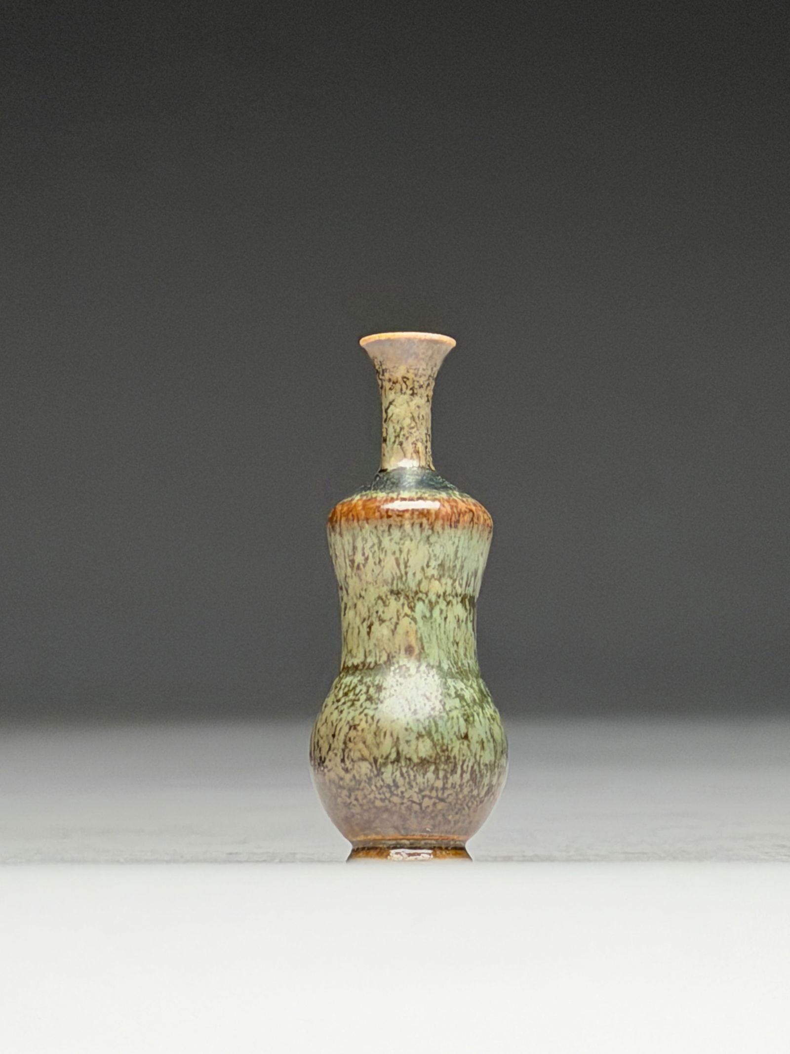 John Andersson Ceramic Miniature Vase - Mid 20th Century: John Andersson Ceramic Miniature Vase - Mid 20th Century This finely proportioned miniature vase presents an elegant, elongated silhouette with a rounded lower body rising into a narrow waist and a sl