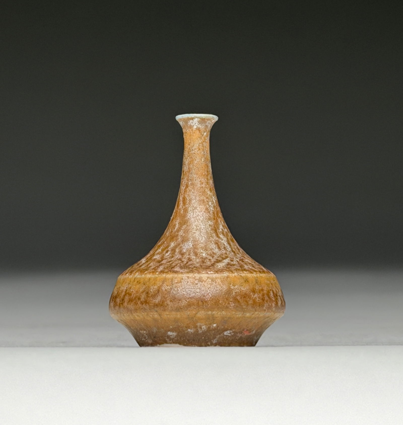 Attributed to John Andersson Stoneware Miniature Vase in Orange Brown Glaze - Mid 20th Century: Attributed to John Andersson Stoneware Miniature Vase in Orange Brown Glaze - Mid 20th Century This diminutive Scandinavian vase presents a compact, rounded lower body rising into a narrow, tapering n