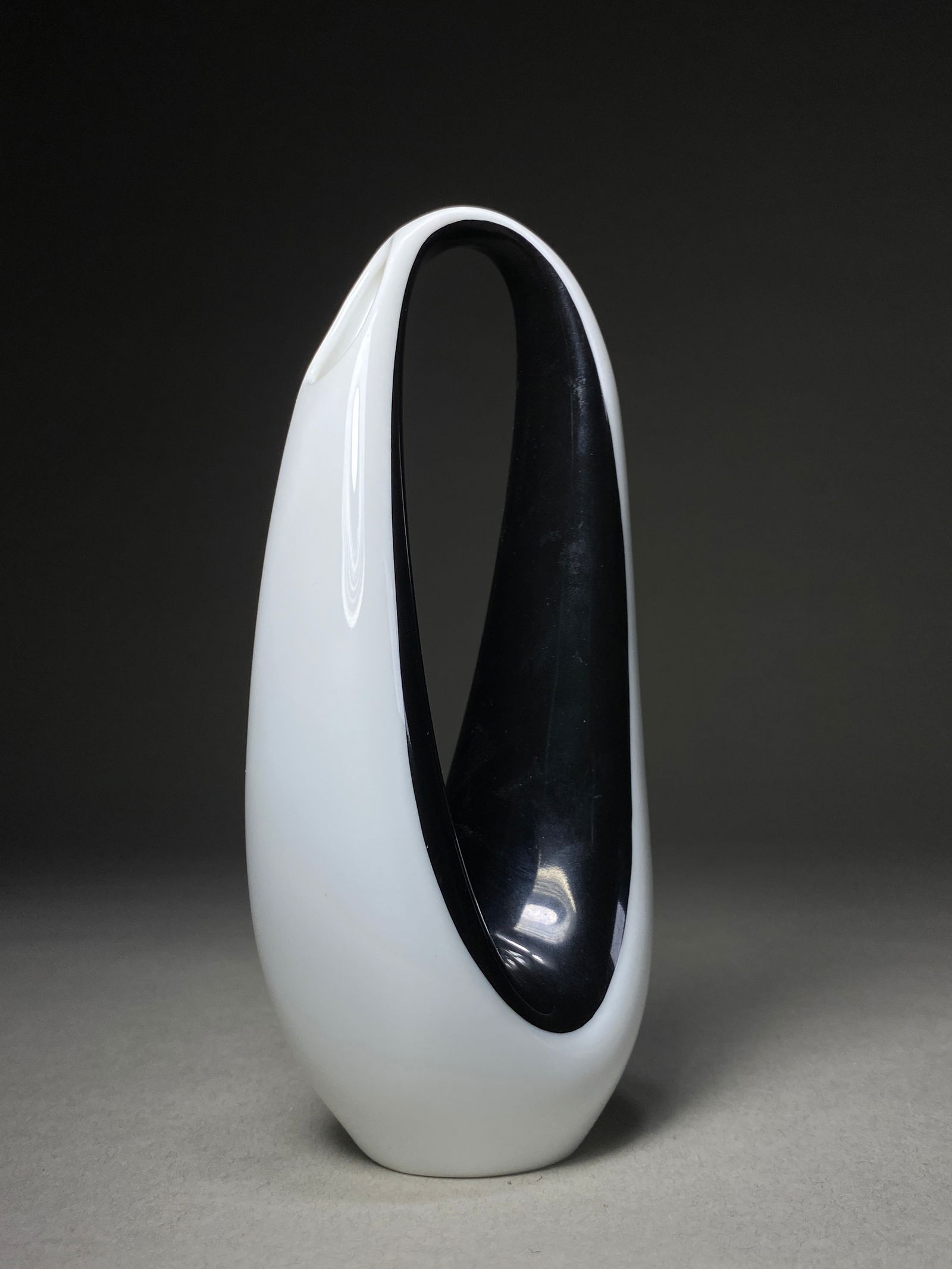 Rosenthal Porcelain Sculptural Vase, German, Mid-20th Century: Rosenthal Porcelain Sculptural Vase, German, Mid-20th Century A striking piece features a dramatic ovoid form with an elegant asymmetrical void that creates a bold interplay of positive and negative s