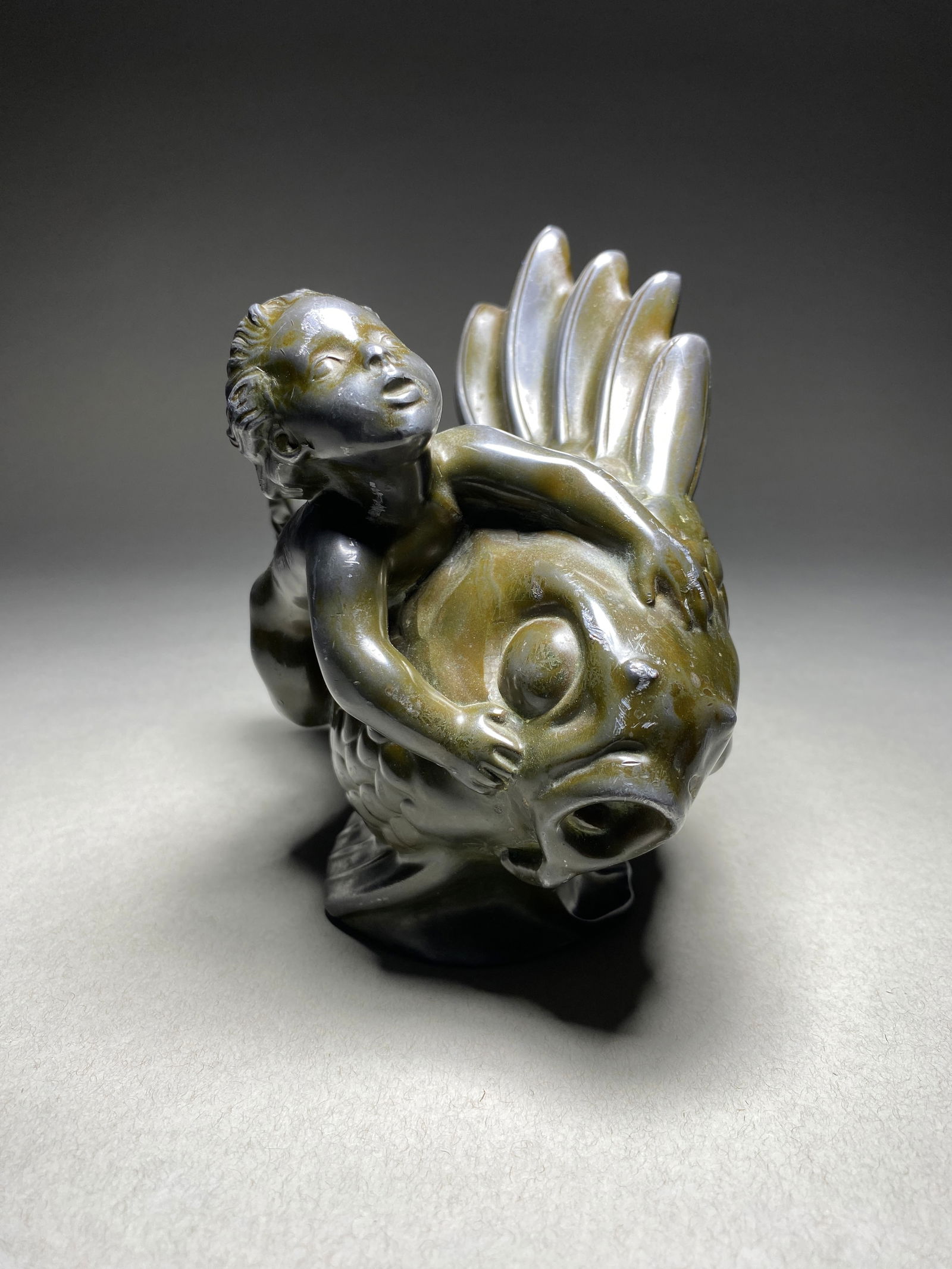 Just Andersen, Merman Riding a Fish, Disco Metal Sculpture, Denmark, 1930s: Just Andersen, Boy Riding a Fish, Disco Metal Sculpture, Denmark, 1930s The sculpture features a stylized boy gracefully riding a fish. The sculpture is cast in a rich, brown patinated disco metal. Th