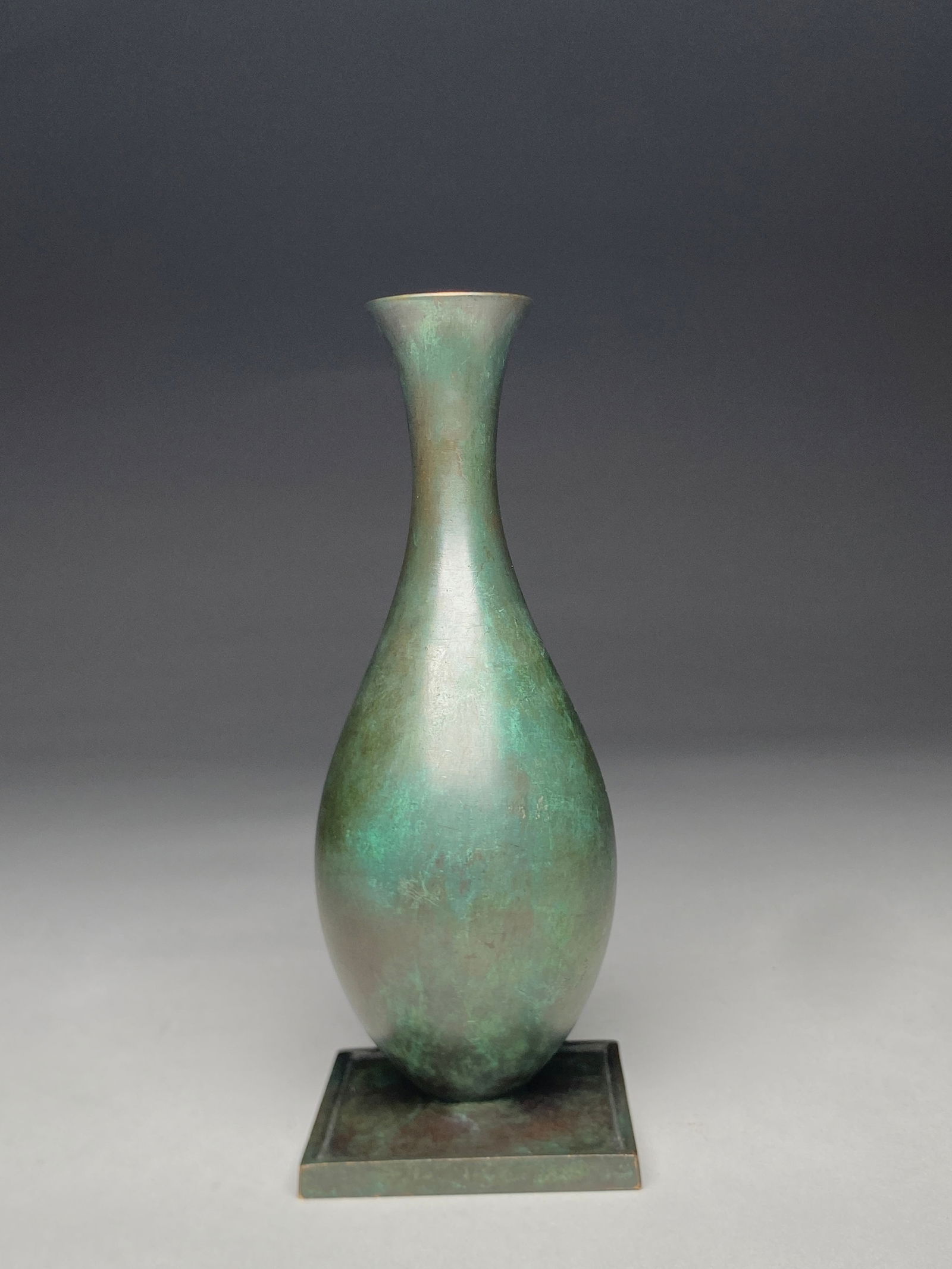 Just Andersen for GAB Bronze Vase - Mid 20th Century: Just Andersen for GAB Bronze Vase - Mid 20th Century A slender bronze vase with a refined baluster form rising from a square base, the surface displaying a soft green patina with subtle tonal variatio