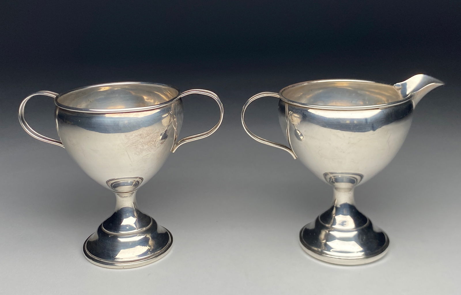 Sterling Silver Creamer and Sugar Set - Early 20th Century: Sterling Silver Creamer and Sugar Set - Early 20th Century The set features a refined neoclassical form with a softly rounded body raised on a stepped circular foot. The creamer has a delicately shape