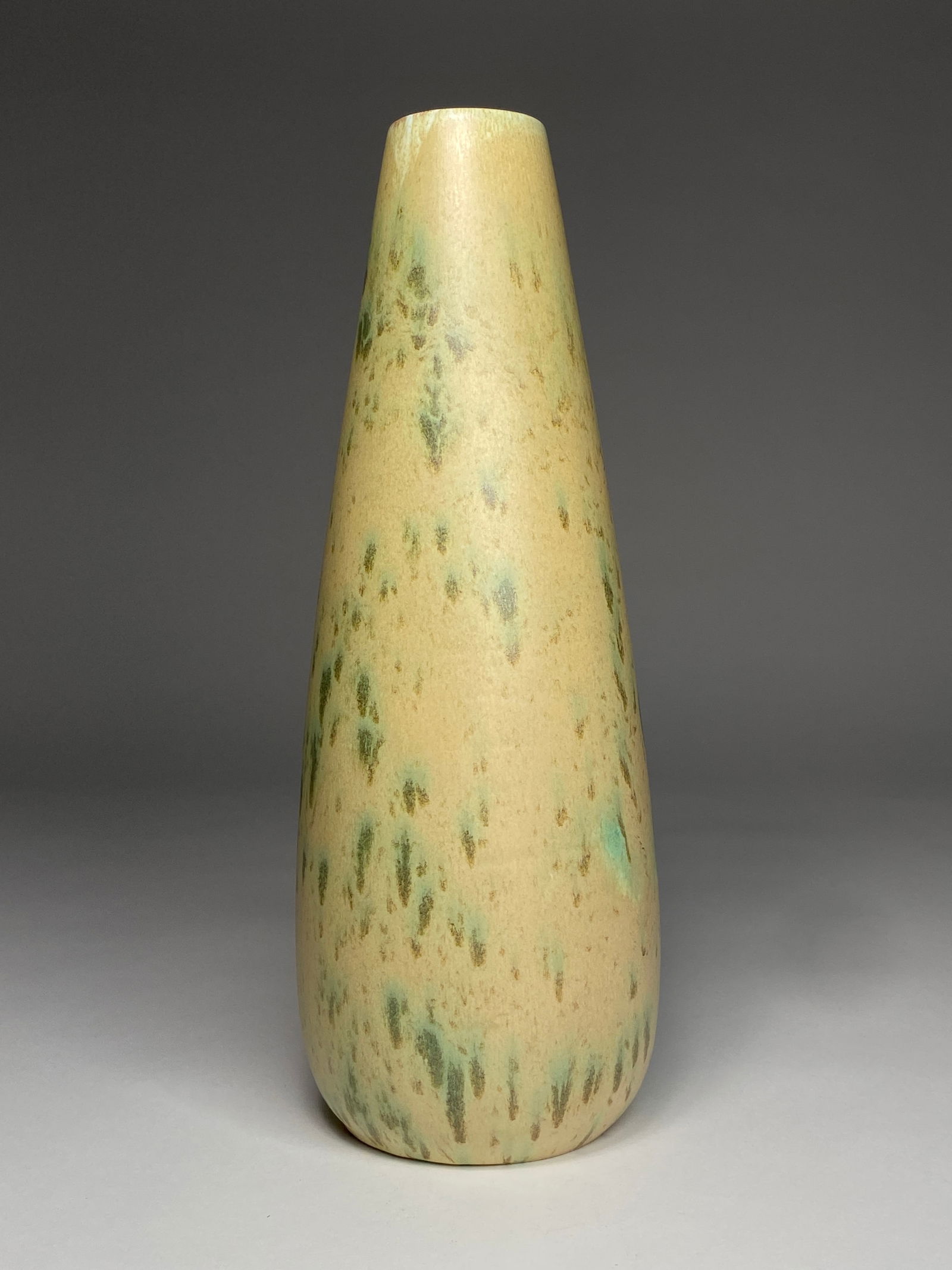 Mid-Century Modern Tall Ceramic Vase - Studio Pottery, Mid-20th Century: Mid-Century Modern Tall Ceramic Vase - Studio Pottery, Mid-20th Century A refined mid-century modern studio vase featuring an elongated bottle form with a subtly tapered silhouette. The surface is fin