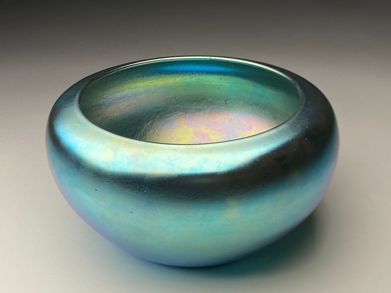 Steuben Glass Blue Iridescent Aurene Squat Vase - Early 20th Century: Steuben Glass Blue Iridescent Aurene Squat Vase - Early 20th Century Steuben form presents a broad, rounded body with a subtly tapered base and wide circular mouth, creating a low, squat silhouette th