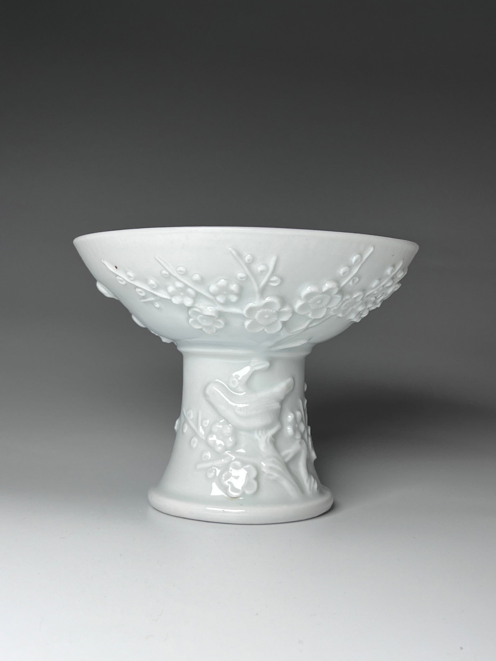 Chinese Porcelain Vessel with Floral Motifs, 18th Century: 18th-century Chinese porcelain vessel highlighted by intricate floral motifs and beautifully sculpted imagery. The design features a delicate arrangement of branches adorned with blossoming flowers, l