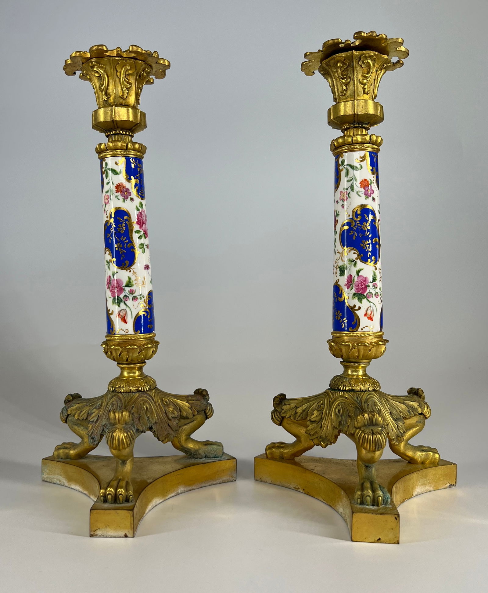 Pair of Russian Empire Porcelain, and gilded bronze candle holders, from Nicholas the First period: Roman "N I" under the crown,The central porcelain column decorated with floral motifs, and blue panels richly gilded. Bronze parts contain original gold, very finely chased. Similarly decorated object