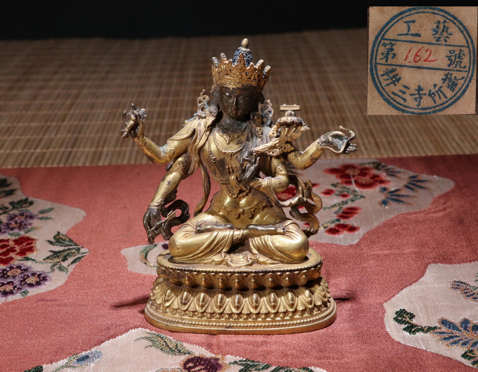 TIBETAN GILT BRONZE SEATED FOUR ARM BUDDHA: TIBETAN GILT BRONZE SEATED FOUR ARM BUDDHA. H.10cm LOT 52 TO LOT 182 FROM COLLECTION OF OWNER OF PLUM BLOSSOM STUDIO. The owner of Plum Blossom Studio is Yakichiro Suma, a native of Akita, Japan. Suma