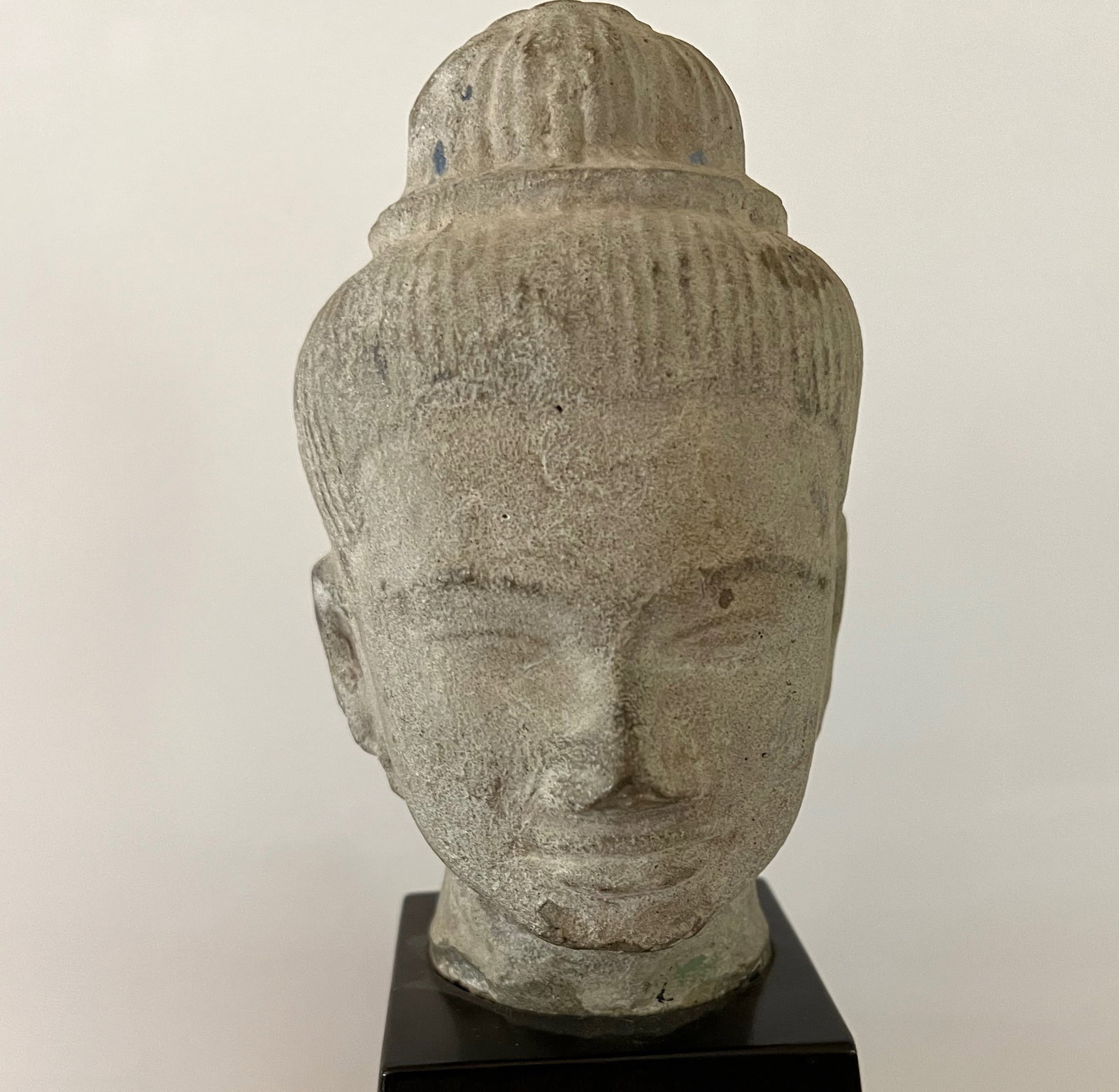 Bronze Head Shiva, Khmer, 10/12th Century: This characteristic bronze cast head of a Shiva with a serene expression, prominent almond-shaped eyes, full lips with a slight smile, ridged eyebrows, broad nose, and framed by large ears under a sim
