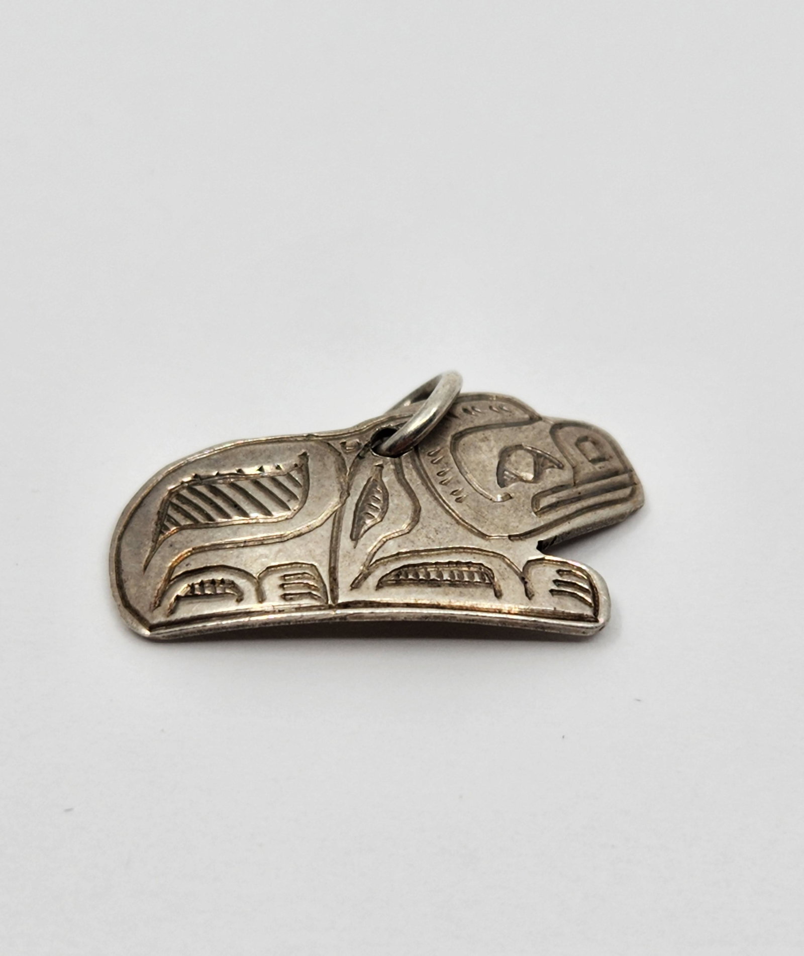 Jeff Pat (1969), Haida, North West Coast: Artist : Jeff Pat (1969), Haida, North West Coast Titre : Jeff Pat (1969), Haida, North West Coast Description (FR) : Pendentif en argent sterling, representant le chien mythique, signee au dos JF Des