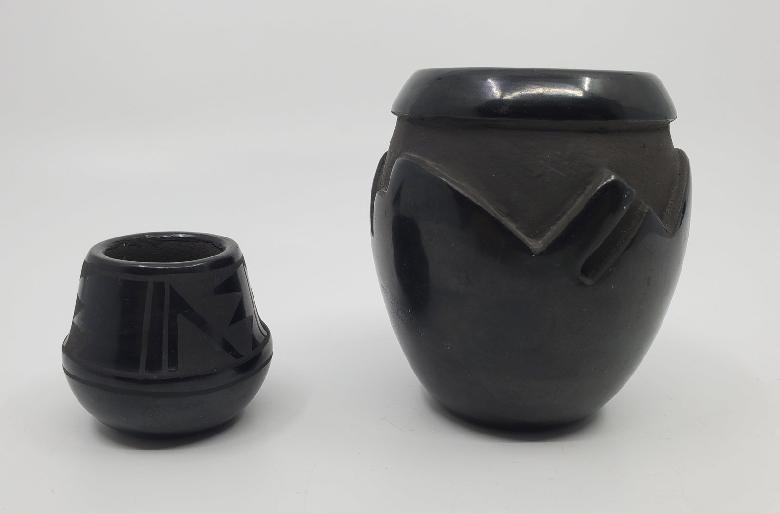 Geri Naranjo, (1953- ) And Margaret Naranjo (XX) Santa Clara Blackware Sgraffito Pot: Geri Naranjo piece c. 2 3/4" high, Margaret Naranjo piece, c. 1 1/2" high
