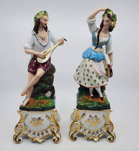 Pair of Antiques Fancy Figurines: Male musician and female dancer, in central European costumes and grape vine headpieces, Both figurines have remnants old stickers from a British Antique Dealers Association indicating that these item