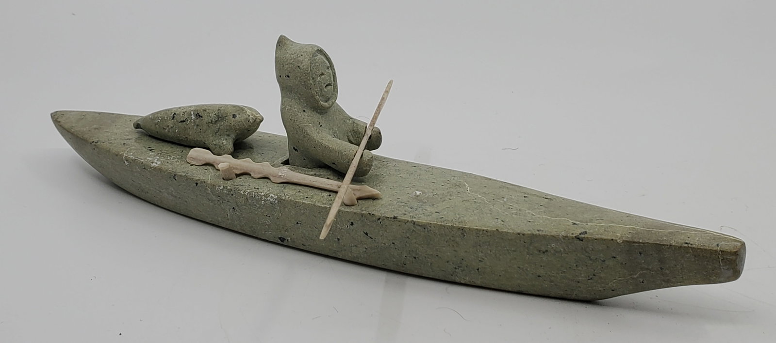 UNIDENTIFIED ARTIST, INUIT, Hunter on Kayak: Artist : UNIDENTIFIED ARTIST, INUIT Titre : Hunter on Kayak Description (FR) : Sculpture en pierre serpentine et os, non signee Description (ENG) : Serpentine stone and bone sculpture, unsigned Diment