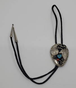 Navajo Nickel Silver Bolo Tie set with Turquoise and Red Coral: 48 x 65 mm. Set with a small red Coral and a narural turquoise, unmarked, with is original leather strap