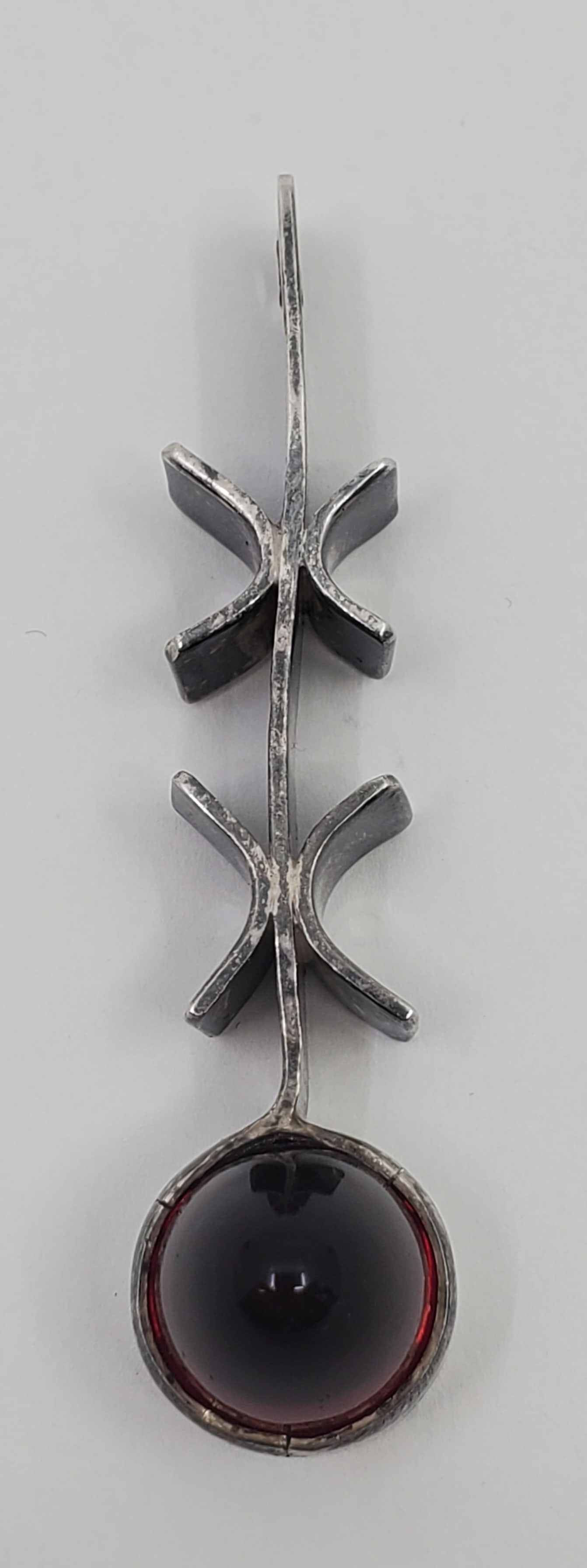 SCANDINAVIAN Modernist Sterling Silver Pendant: 18.16 grams, 61 mm Stamped STE Set with an elonginated conical cabuchon wine-red stone, probably a garnet. measurin 12 x 14 mm.