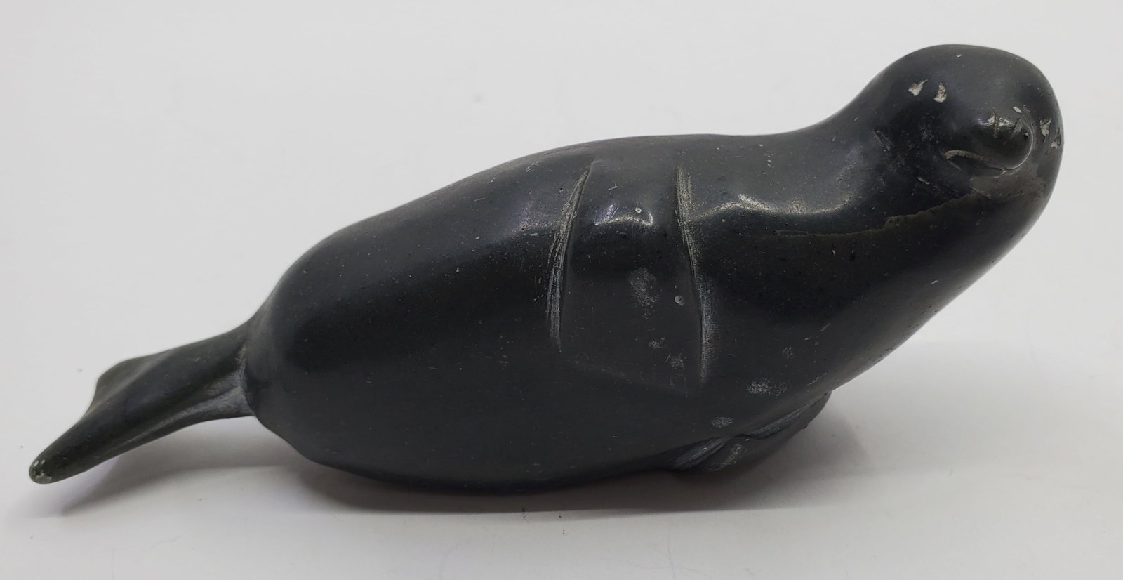 UNIDENTIFIED ARTIST, INUIT, Seal: Serpentine stone sculpture, marked underneath 3980 with a Eskimo Art Sticker 2" x 4 1/2" x 1"