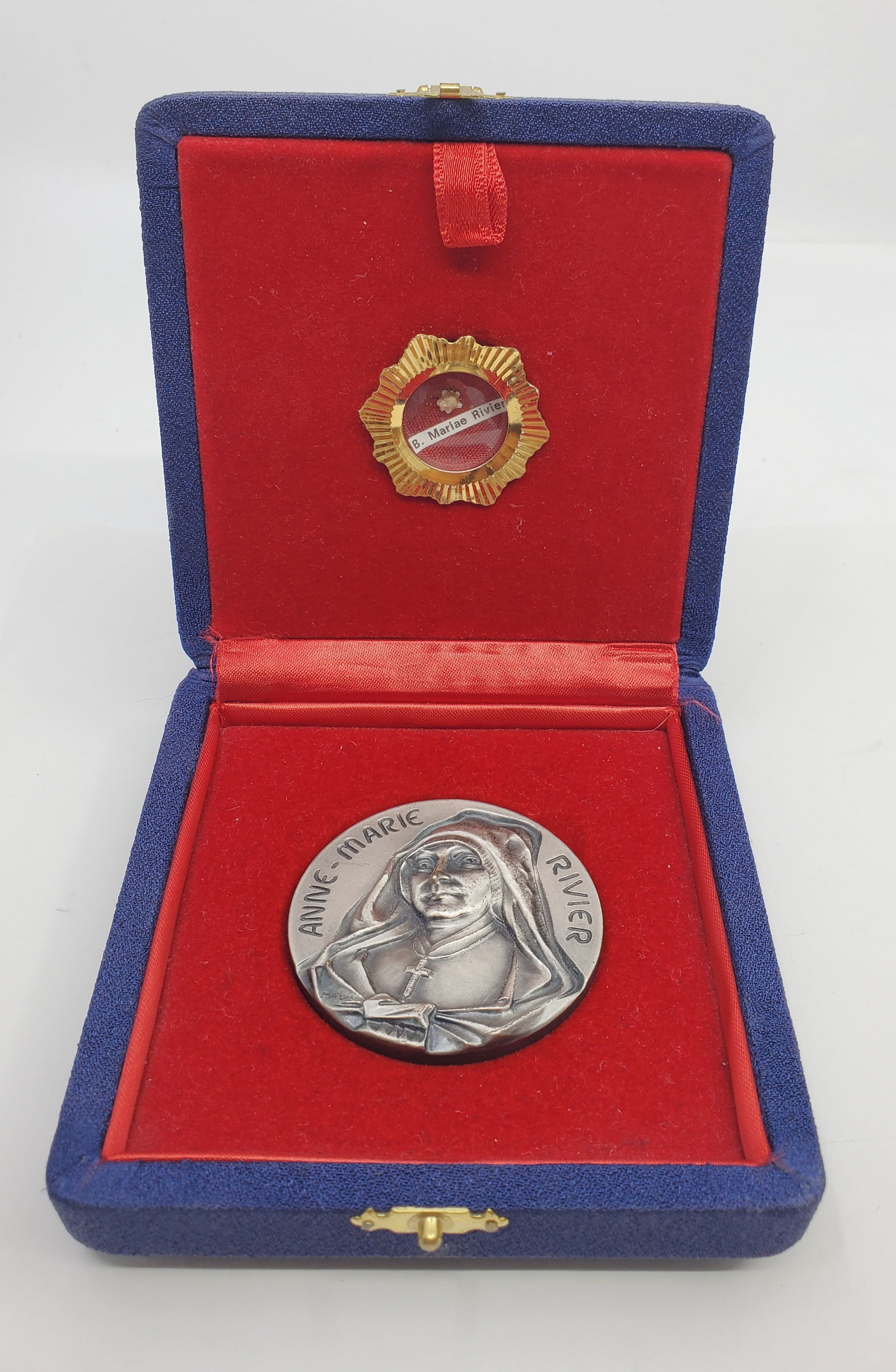 Boxed Medal with RELIC Beatification of Anne-Marie Rivier 1982: 50 mm, 75.06 grams Unstamped, possibly silver plated bronze. Inserted in the inner top of the case is a 28 mm wide glass fronted brass case containing a smallrelic,possibly hair.