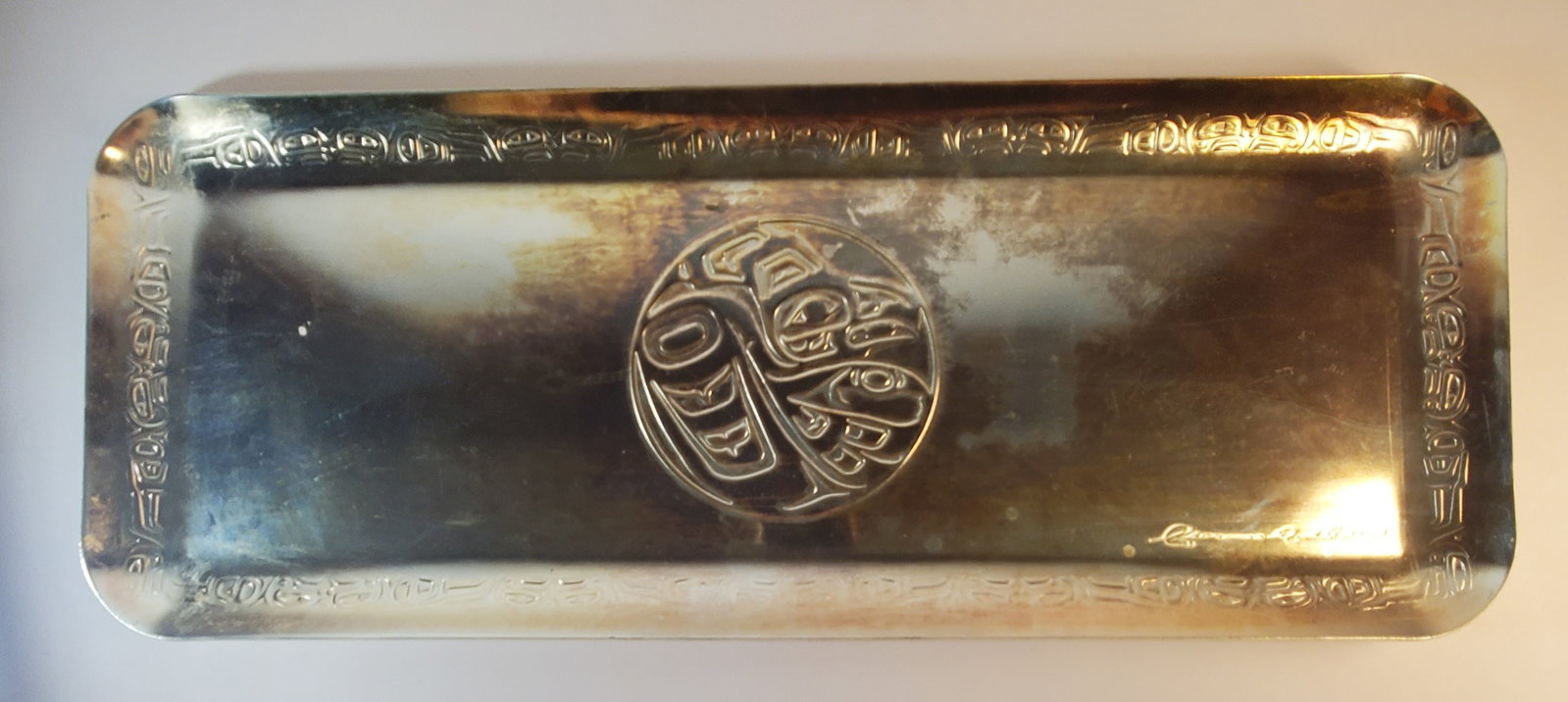 CLARENCE A. WELLS First Nations Handcrafted Silverplate Tray: 3/4 x 7 3/4 x 19 3/4". Mr Wells (1950-) is a renowned artist and carver of the Gitxsan Clan of the Tsimshian. Please see our other listings for more works by this artist.