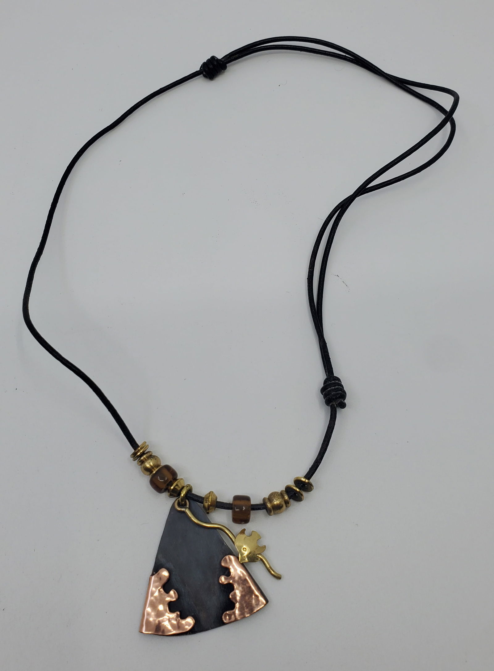 Chris Anderson, Modernist Copper and Leather Pendant Necklace: Copper Pendant with Leather Strap Necklace, Marked on the back Chris Anderson Pendant : 1 1/2" x 1 1/2"Necklace : 20" (Adjustable)