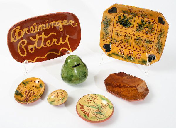 Lester Breininger, Glazed Redware Dishes: Lester Breininger (American, 20th Century) Five Pennsylvania German Glazed Redware Dishes, a Pear-Shaped Coin Bank and a Decorative Egg, ranging in size from 4-1/2 inches to 9-1/2 inches (dish diamete